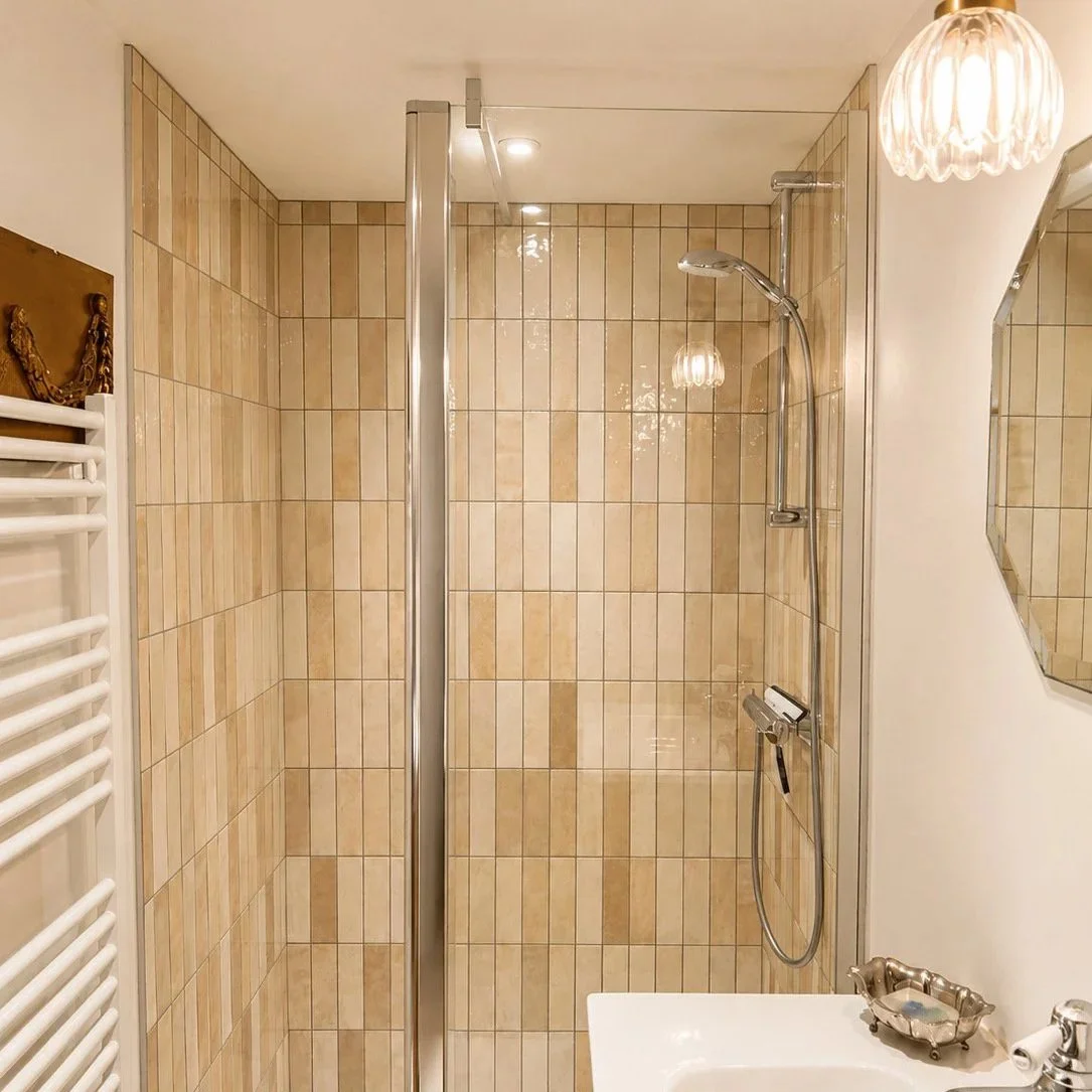 Salle de bain rénovée à Luzy dans le Morvan, avec douche à l’italienne, carrelage beige et matériaux naturels