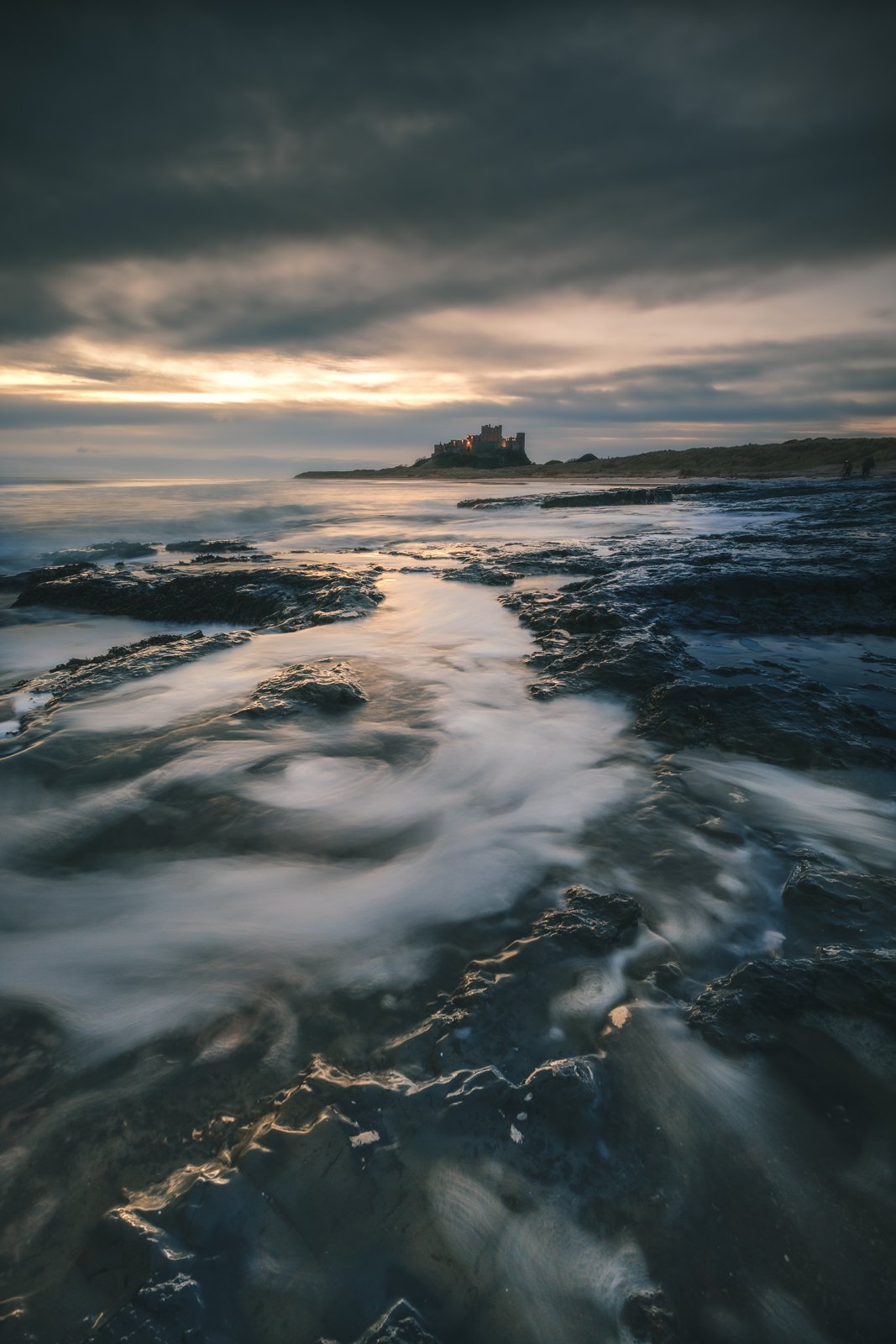 Leading over the pools of sea water, Bamburgh castle appears into the distance.