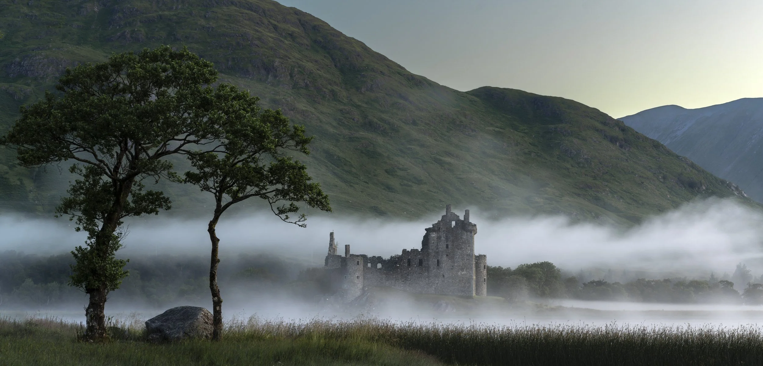 Kilchurn castle with layers of fog flowing past.