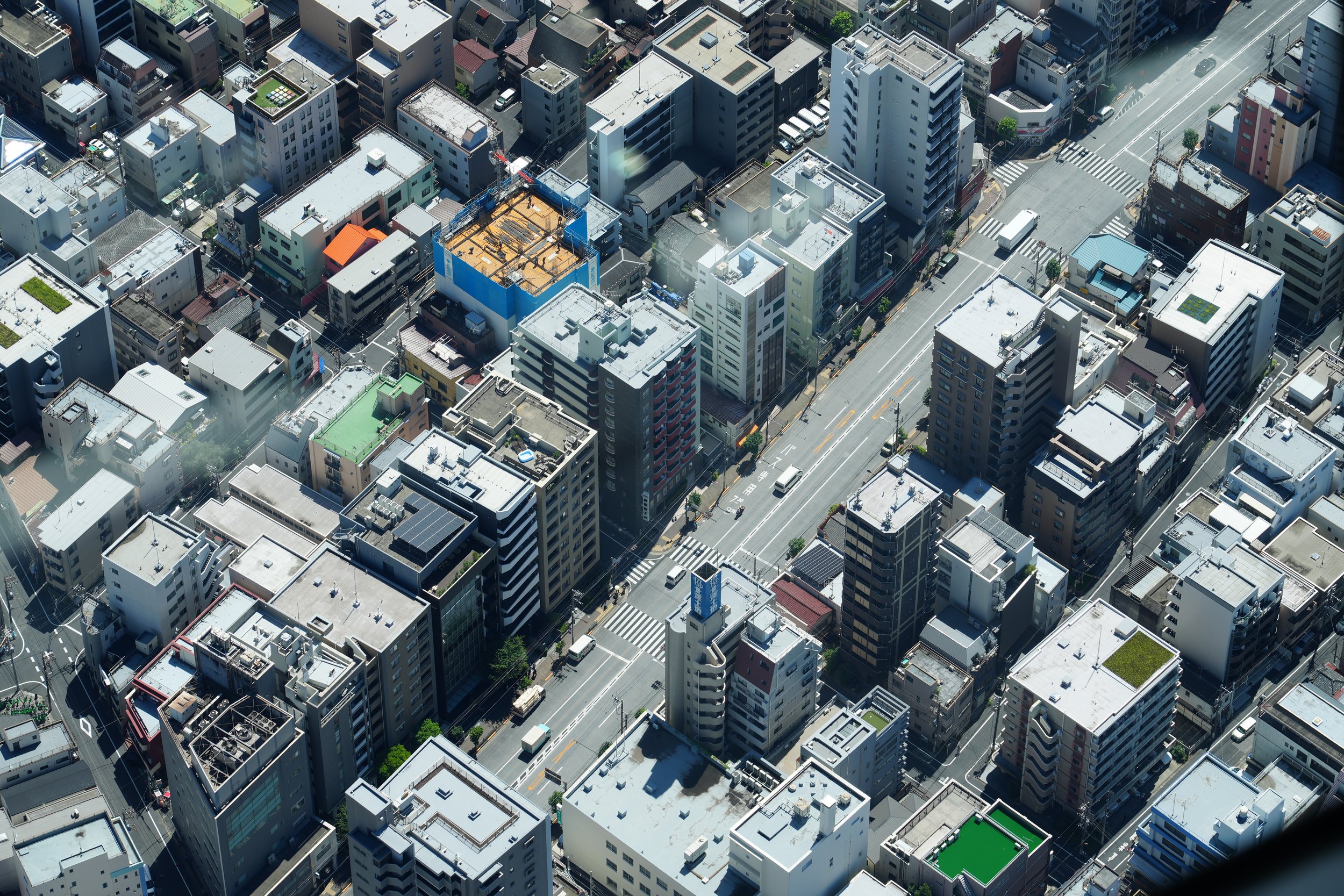 An aerial view of a city with numerous high-rise buildings, streets, and vehicles.