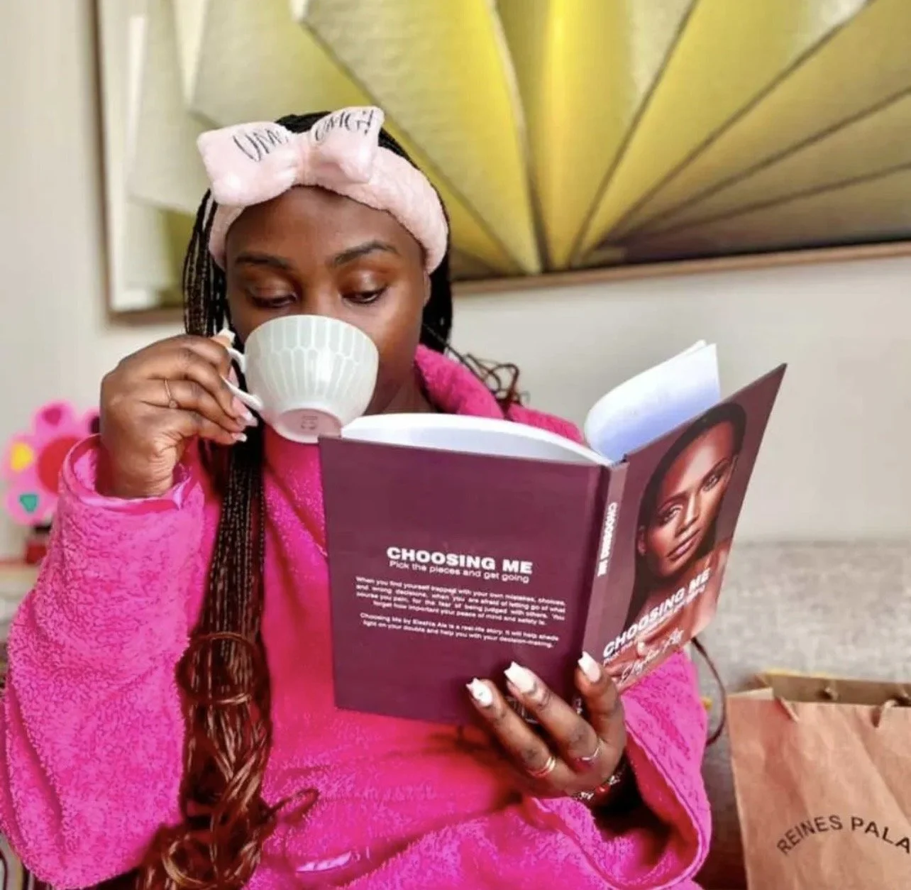 Woman reading a book titled 'Choosing Me'  by Eleshia Ais.