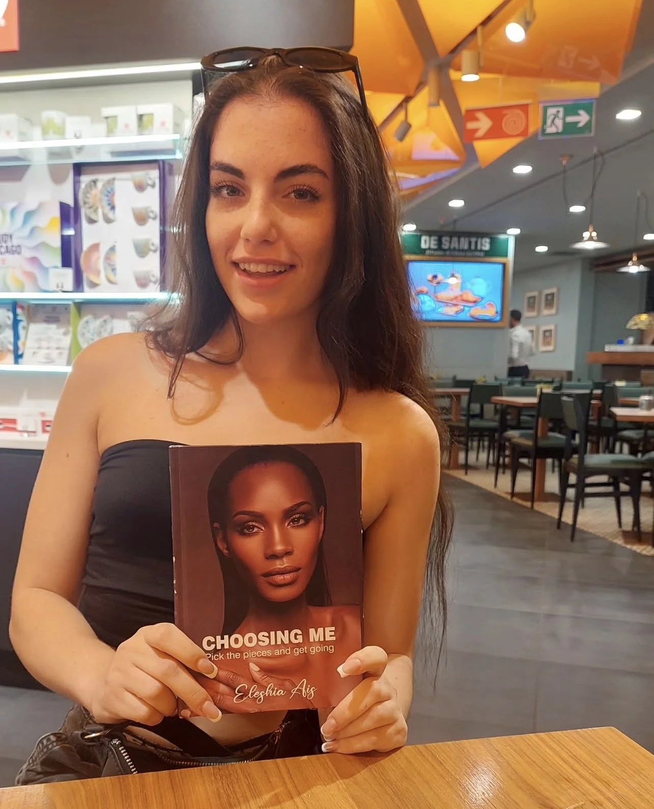 A girl holding 'Choosing Me'  book by. Eleshia Ais.