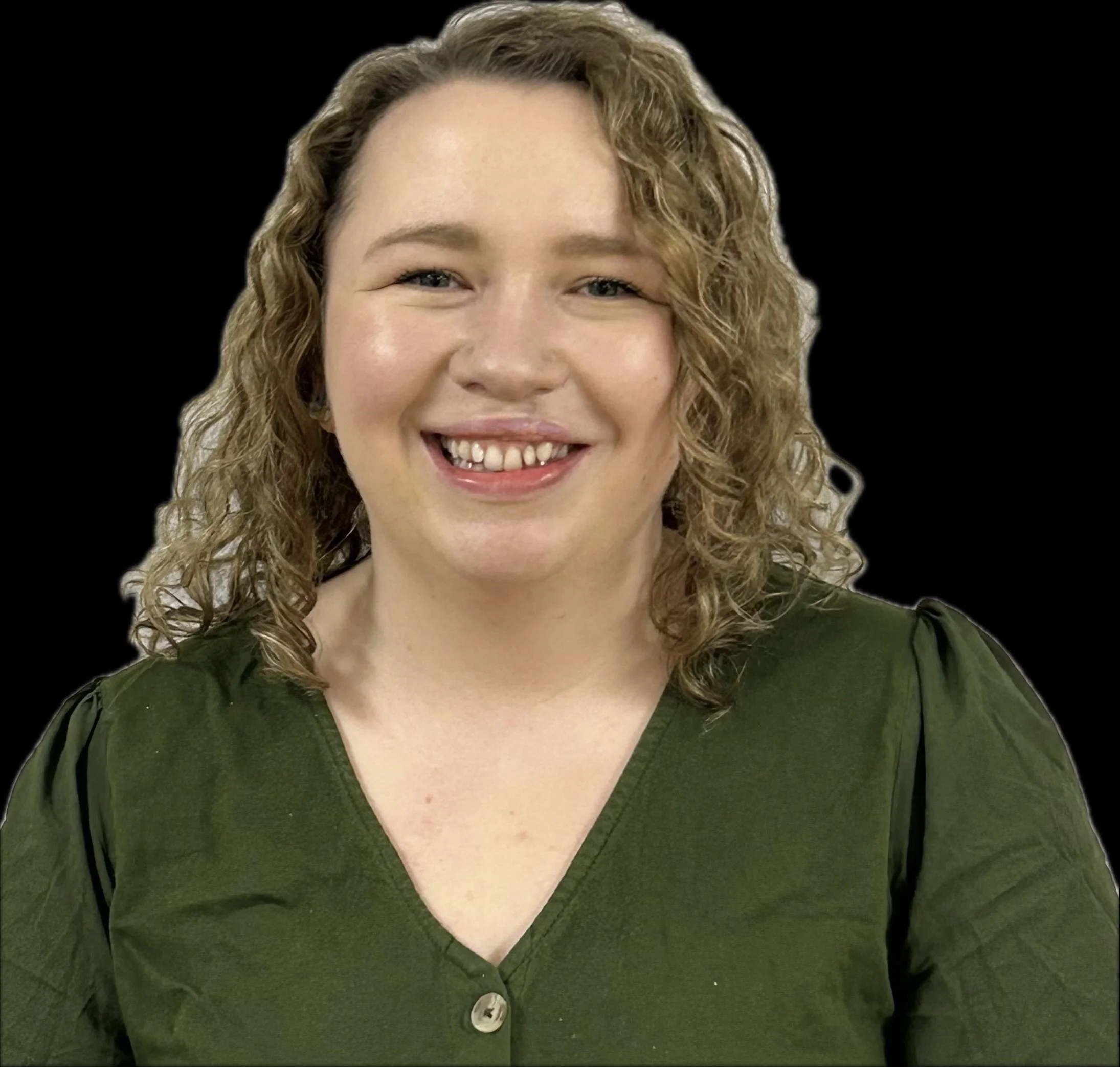 Close-up of a woman smiling, wearing a dark green V-neck blouse, with curly blonde hair and light skin.