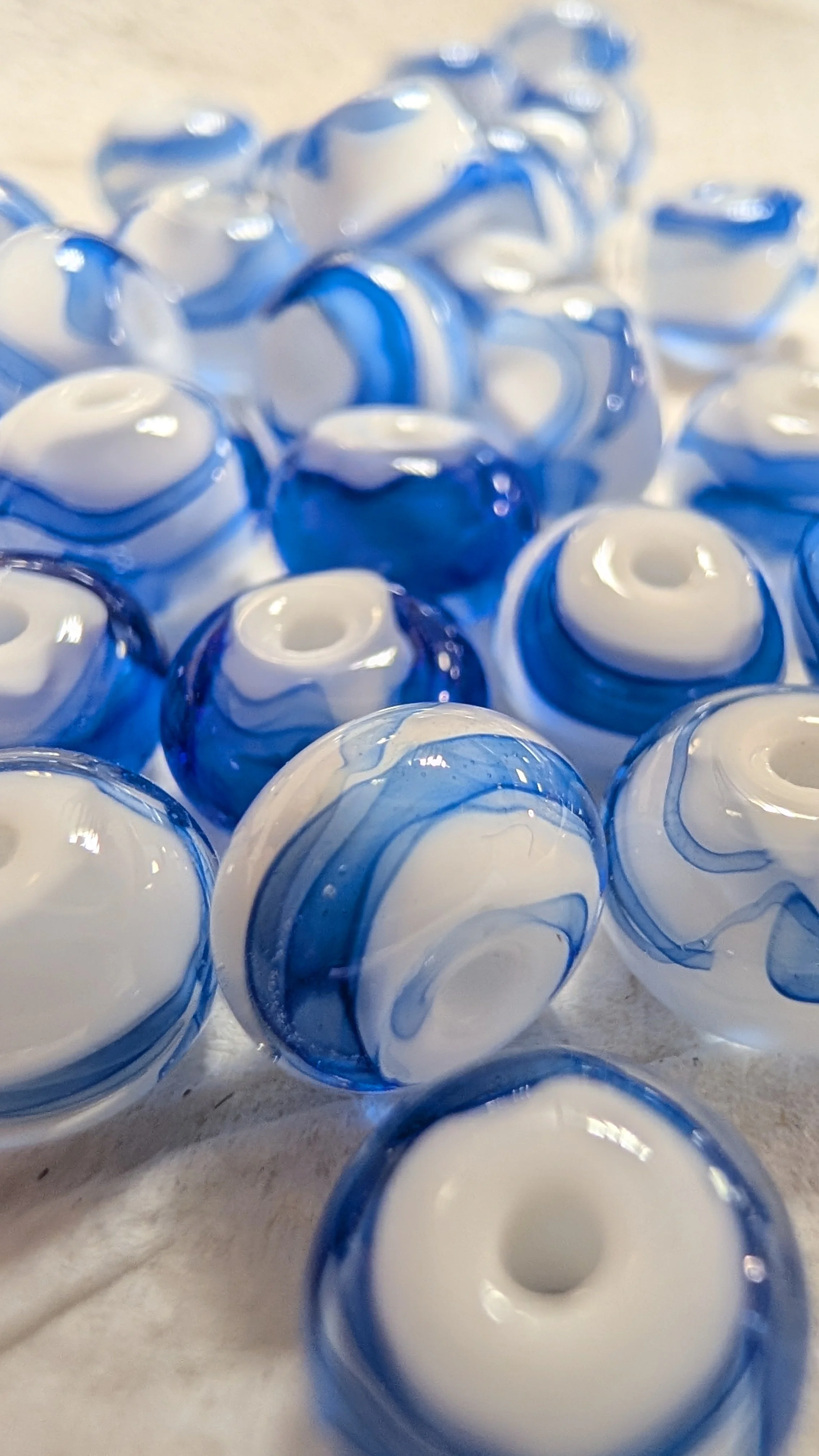 Gros plan sur un groupe de billes en verre bleues et blanches.
