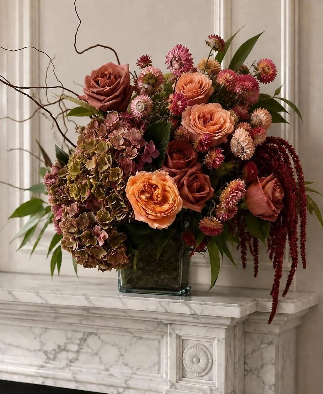 Luxury floral arrangement with roses, hydrangeas, seasonal flowers and foliage arranged in a glass vase.