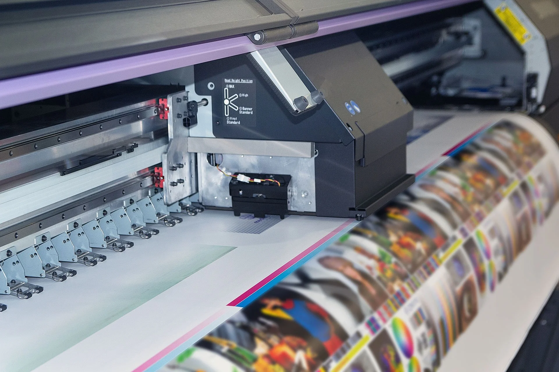 A large format printer producing a colorful magazine or brochure.