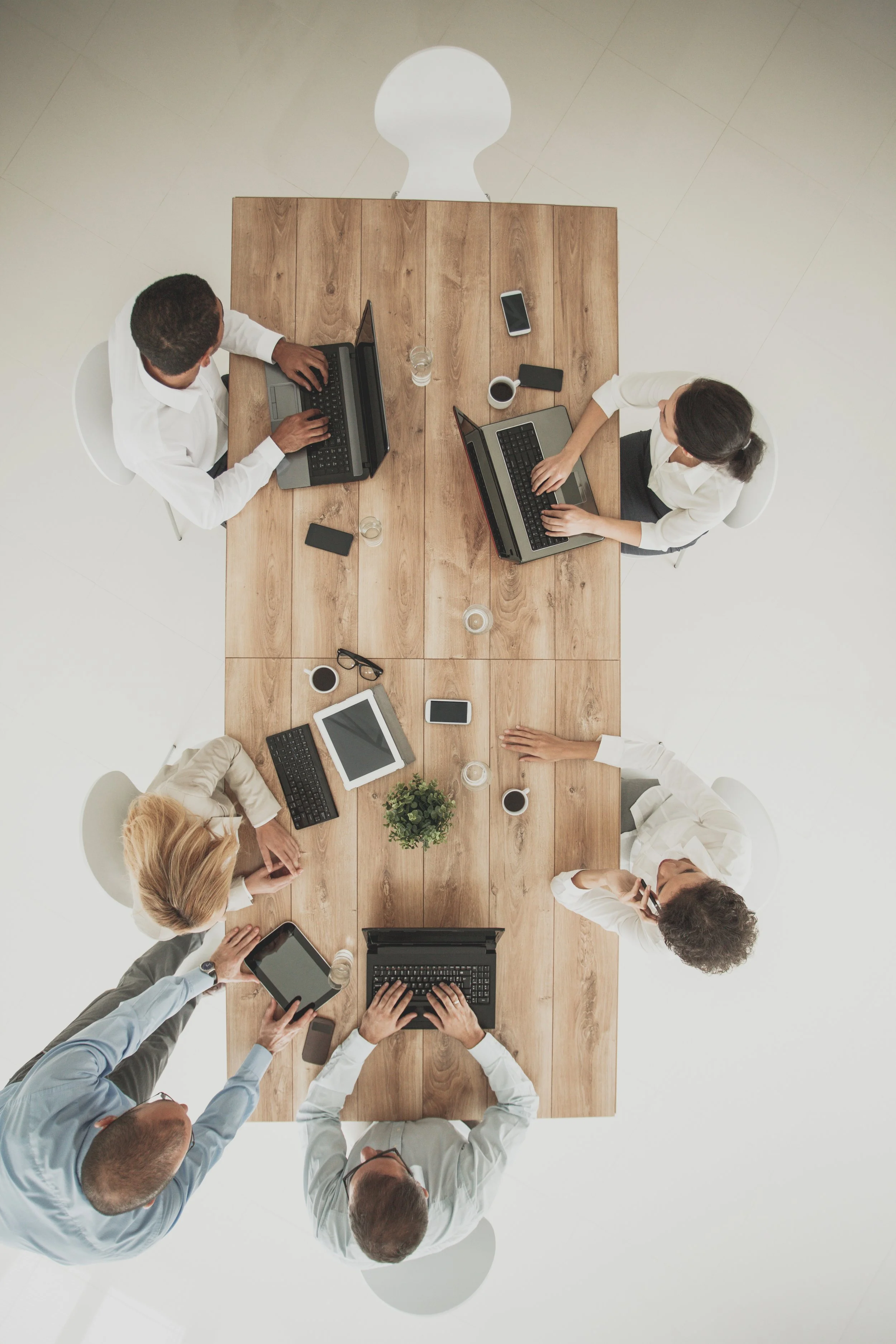 Executive team collaborating around a modern oak conference table on strategic marketing architecture and enterprise growth systems