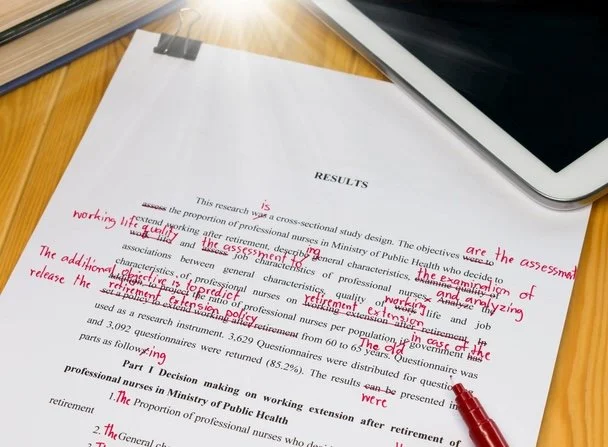 A picture of a typed piece of paper with many red proofreading marks