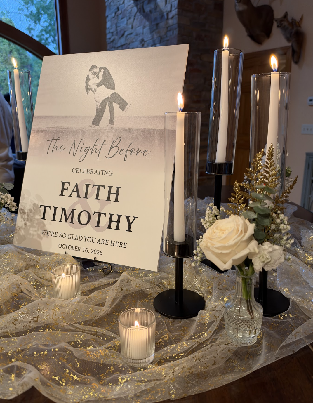 A wedding sign with the couple's names, Faith and Timothy, celebrating their wedding on October 16, 2026. The sign features an image of a couple dancing, surrounded by candles, flowers, and gold-accented decorations on a table.