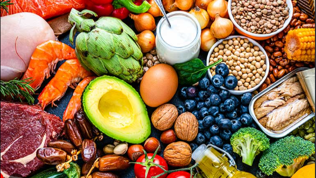 A variety of healthy foods including vegetables, fruits, nuts, grains, dairy, and meat.