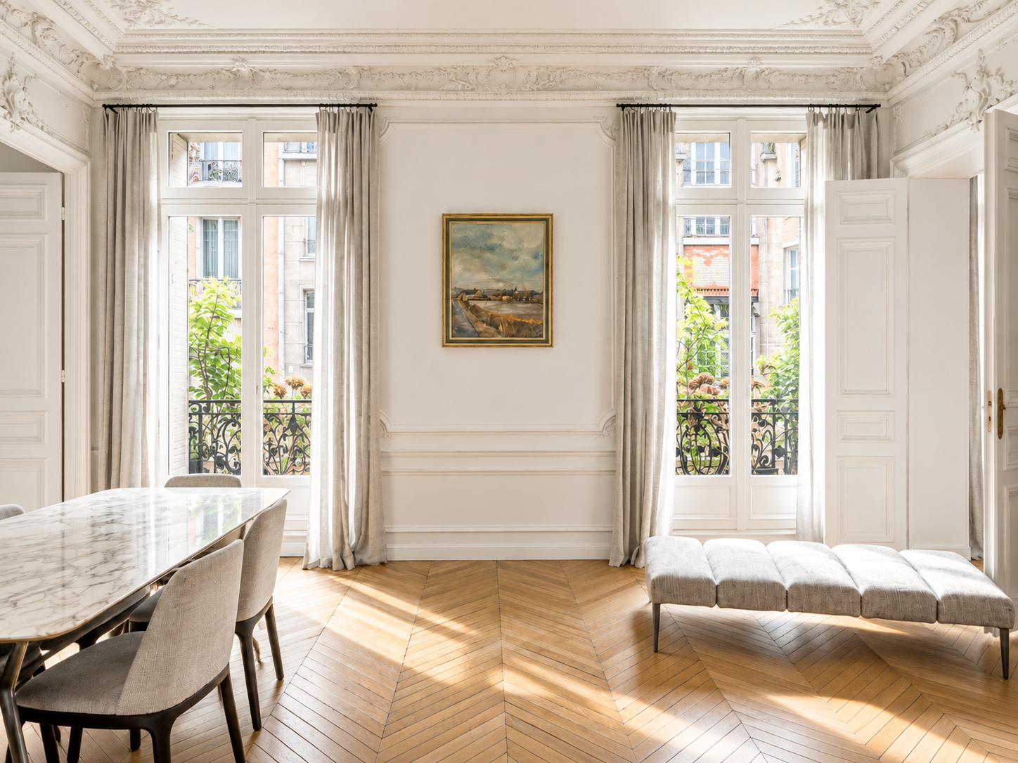 A bright, elegant room with large windows, beige curtains, a marble dining table with chairs, a painting on the wall, and a cushioned bench along the window.