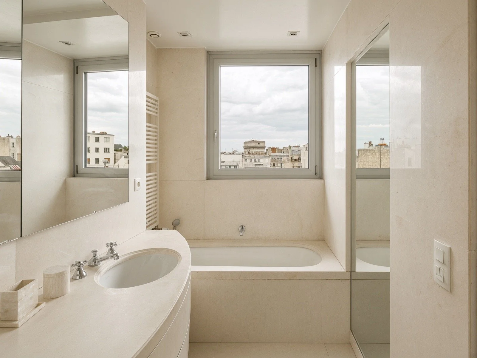 Bathroom with a window, bathtub, mirror, and sink with a countertop.