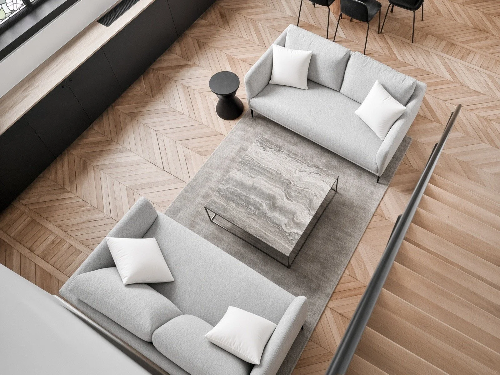 Top-down view of a modern living room with two light gray sofas, white pillows, a marble coffee table, a beige rug, and a black side table on a herringbone wooden floor.