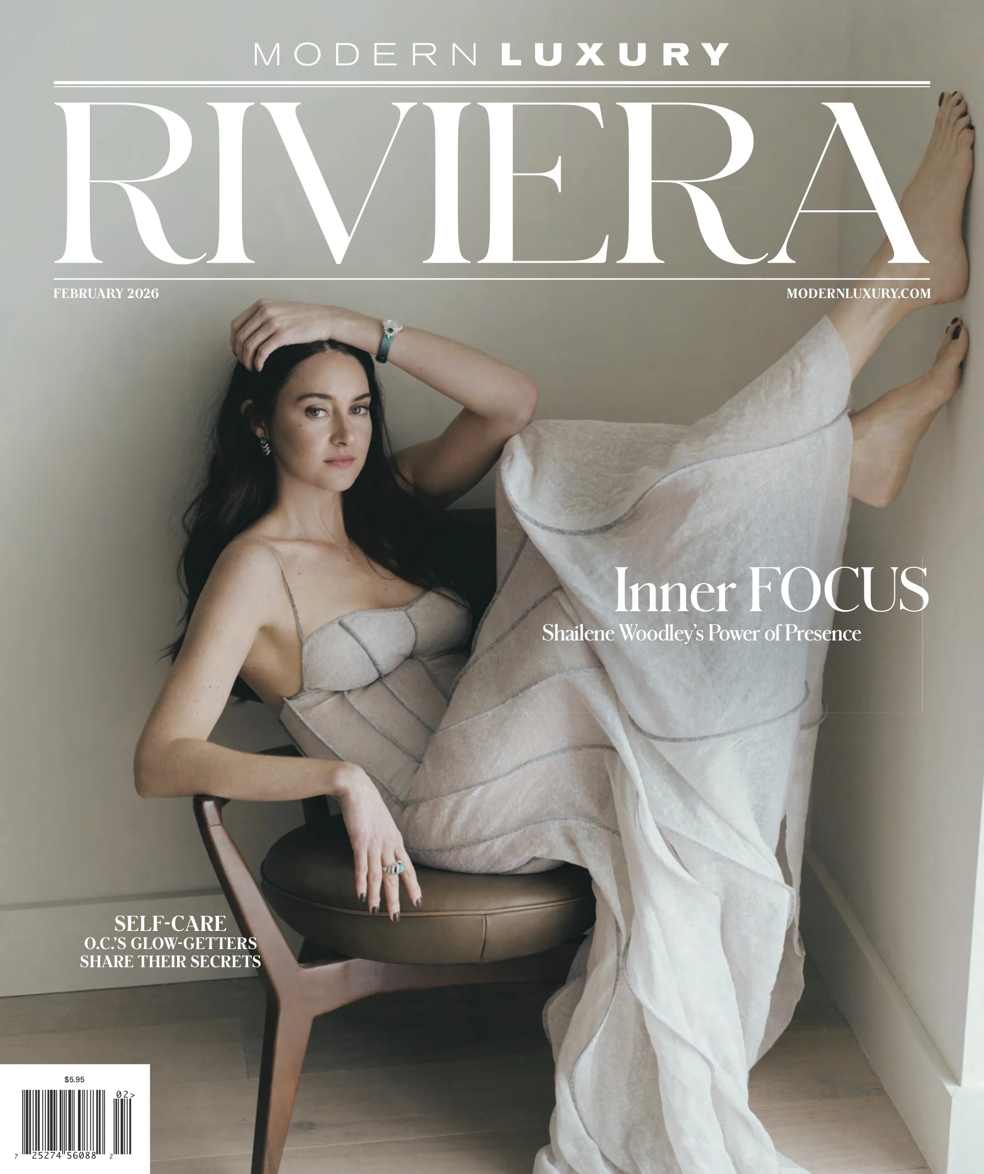 Cover of Modern Luxury Riviera magazine, February 2026 issue, featuring a woman with dark hair sitting on a chair, wearing light-colored, possibly silk, clothing, with her right hand resting on her head and her left hand on her knee. The background is a plain wall, and there is a barcode and price at the bottom left corner. The cover includes headlines about self-care and inner focus.
