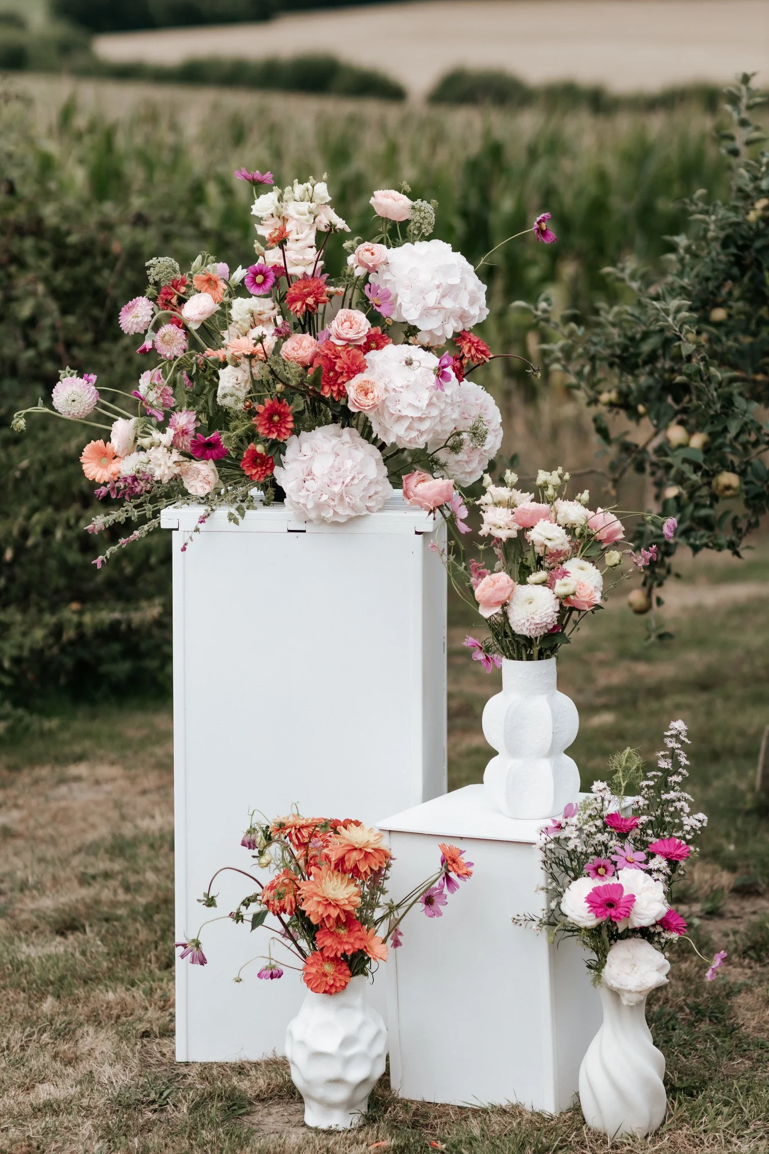Les clients de Laurie, Mariana et Carmen, se tenant la main sur une pelouse verte le jour de leur mariage.