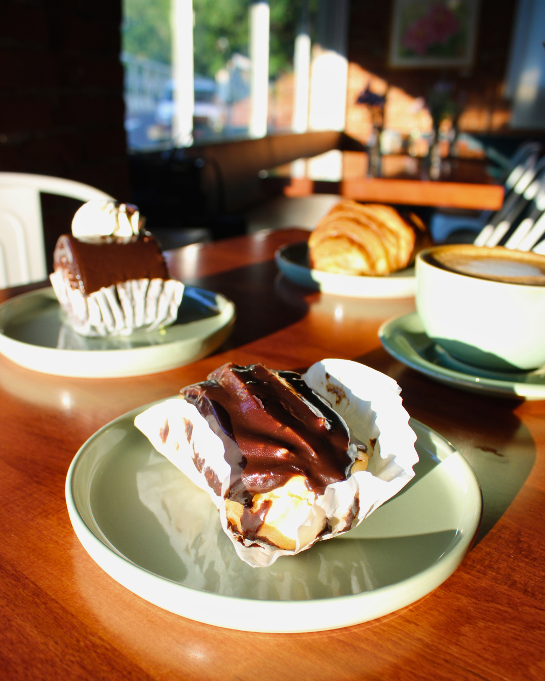 Chocolate-drizzled éclair from Talia’s Bakery served with coffee at Jimmy’s Coffeehouse in Clinton, NJ.