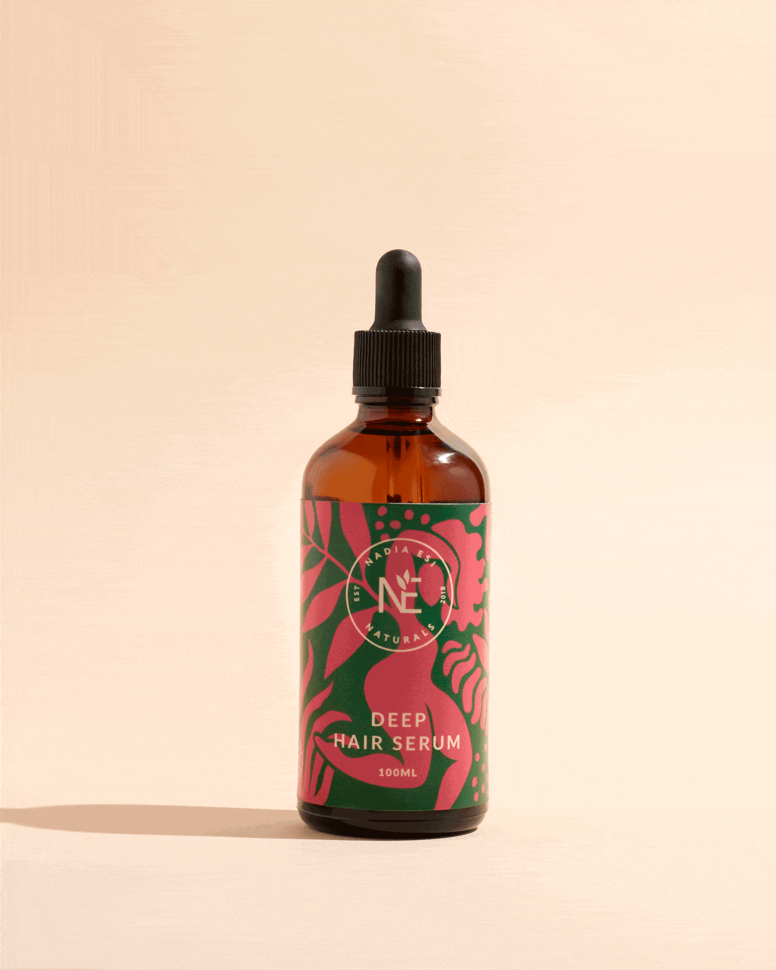 A brown bottle of deep hair serum with a black dropper cap against a beige background.