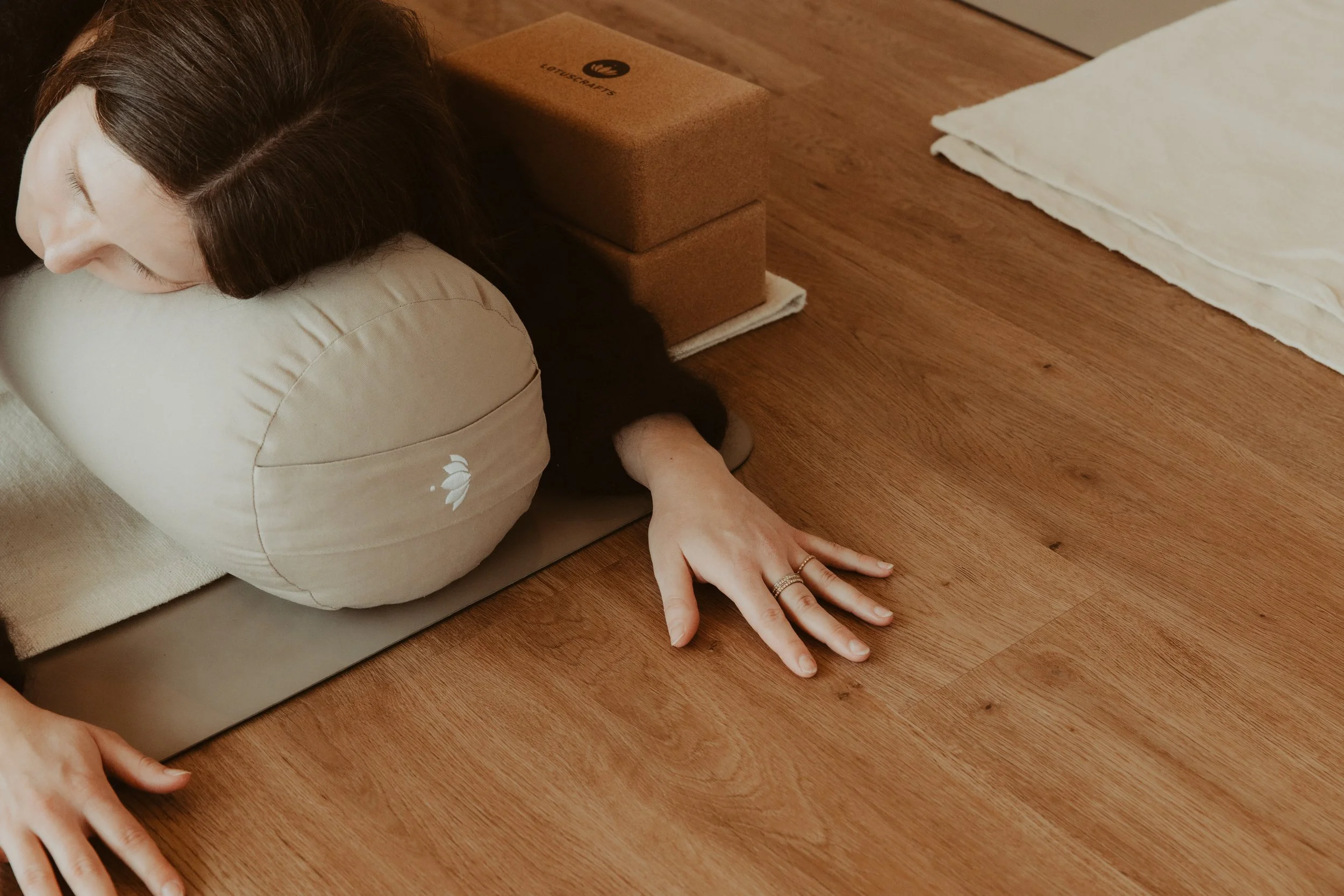 estorative-Yoga-Haltung mit Bolster und Yogablöcken zur Unterstützung
