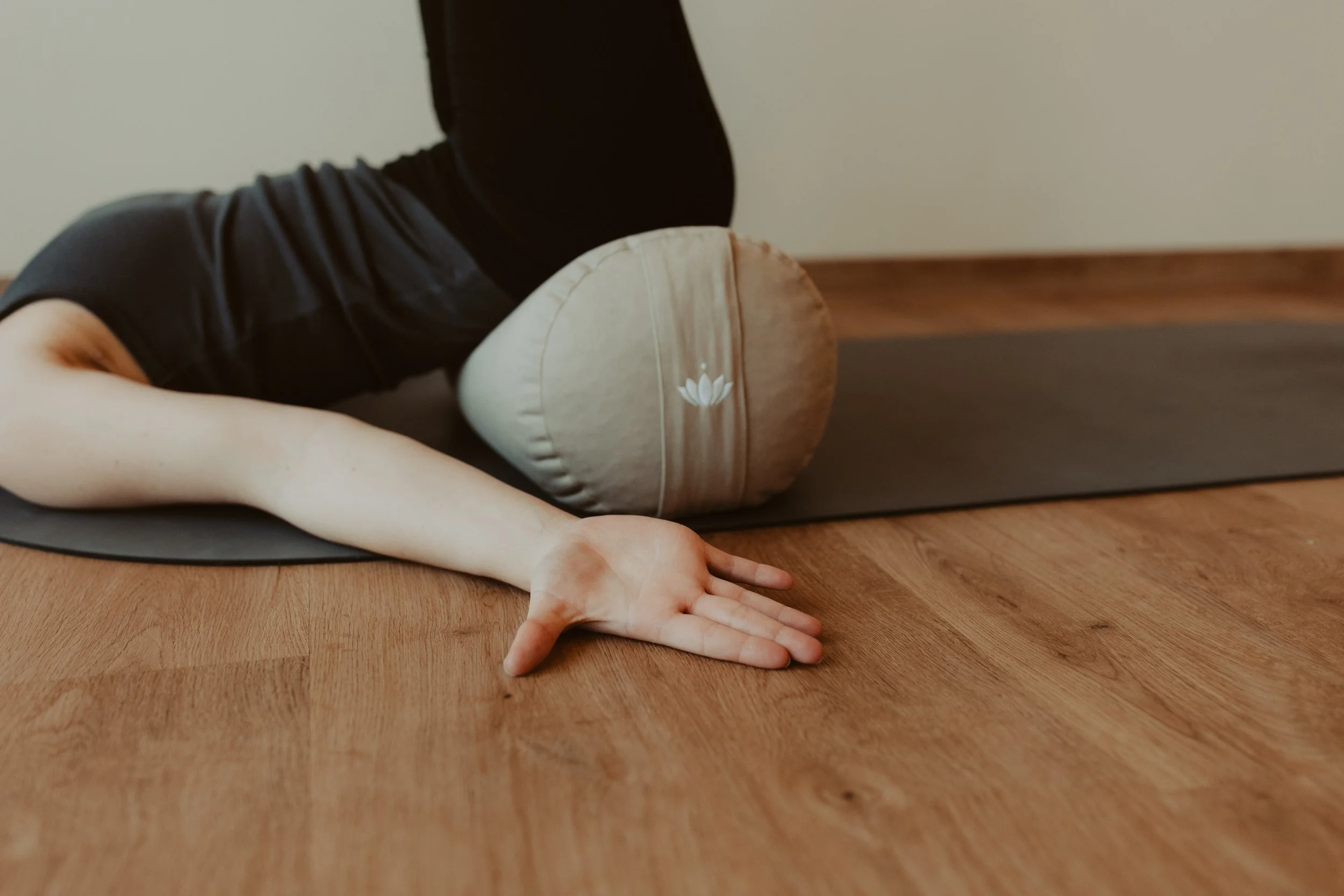 Entspannte Yoga-Haltung mit Bolster während einer ruhigen Yogapraxis
