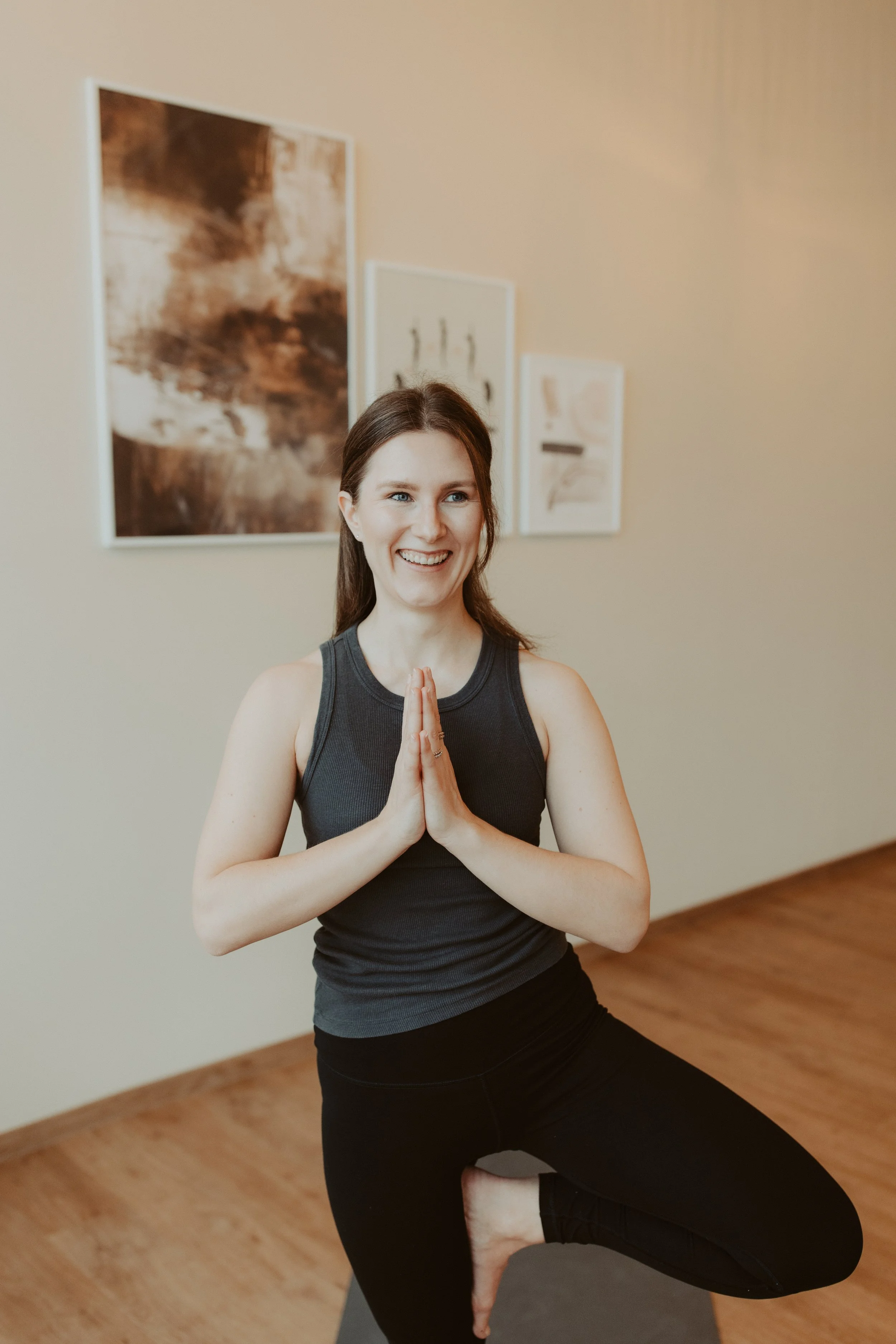 Yogalehrerin Melissa Rieder sitzend auf der Yogamatte mit den Händen vor dem Herzen