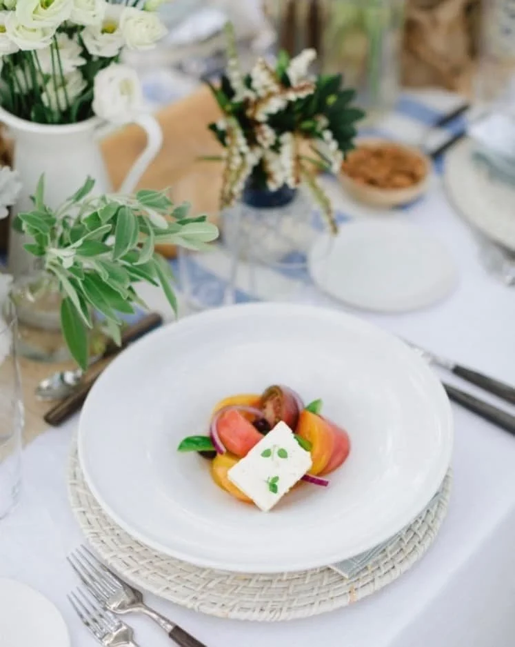Plated tomato and basil course presented at an elegant dinner table.