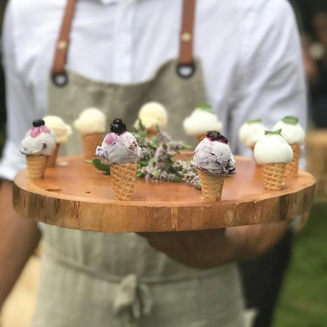 PCK server presenting a tray of miniature ice cream cone desserts.