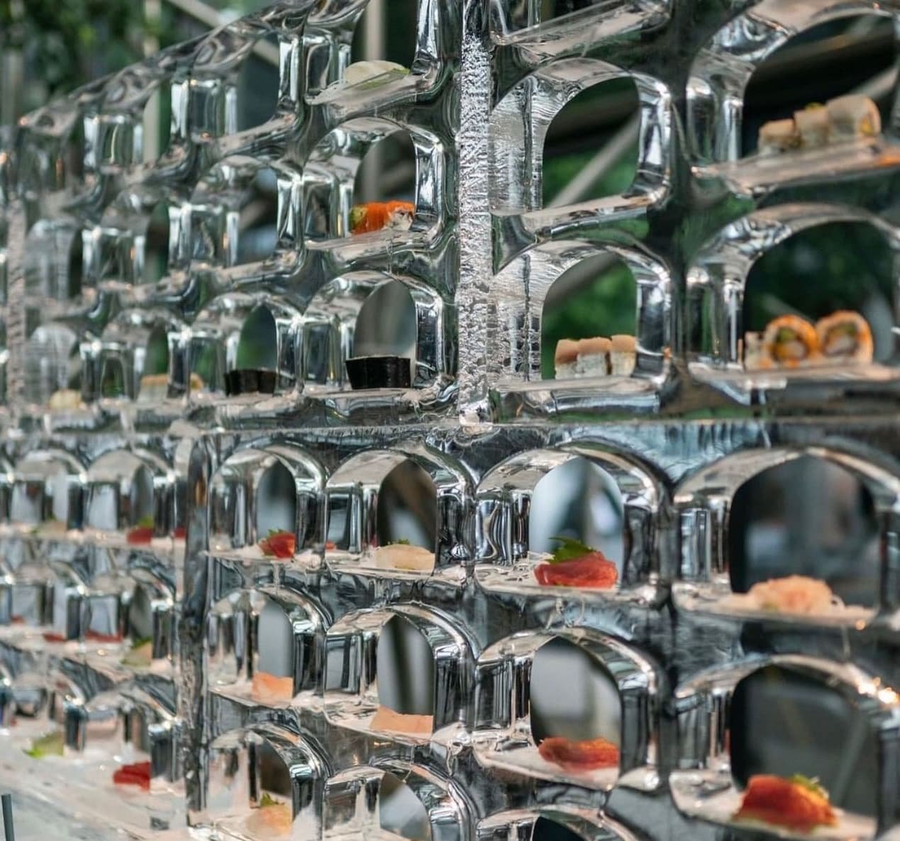 Individual sushi pieces displayed on a custom metal conveyor.