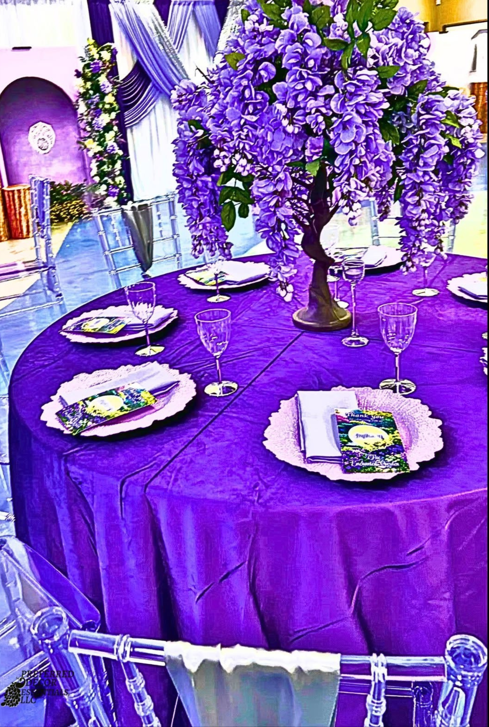 An Enchanted Sweet 16 brought to life with tree centerpieces, layered purple tones, and silver accents.   A life‑sized butterfly and a blooming garden backdrop complete this dreamy, storybook inspired celebration.
