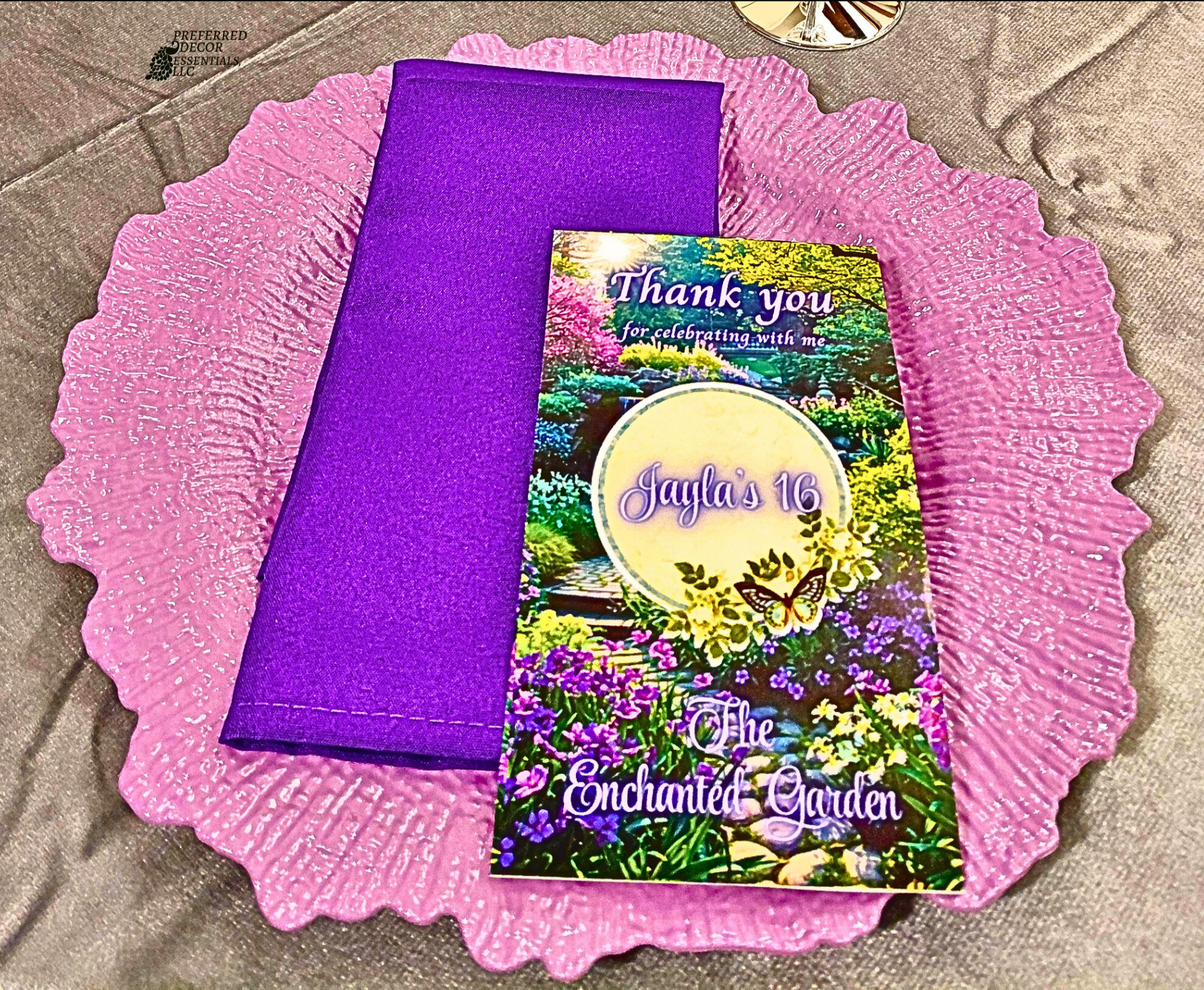 An Enchanted Sweet 16 brought to life with tree centerpieces, layered purple tones, and silver accents.   A life‑sized butterfly and a blooming garden backdrop complete this dreamy, storybook inspired celebration.