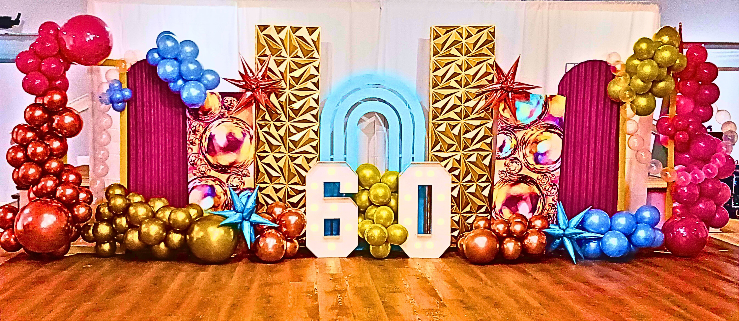 A vibrant 60th birthday celebration featuring a rich rainbow color palette, velvet tablecloths, lush rainbow florals, and touches of gold for a timeless, joyful look.  A fabulous milestone beautifully honored.