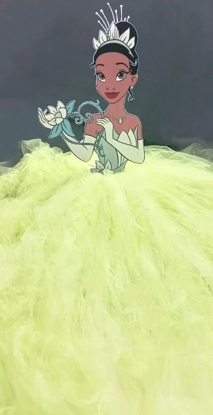 The Princess and the Frog character sketch with, brown eyes, and black hair wearing a yellow ball gown, a crown, and jewelry, holding a white flower.
