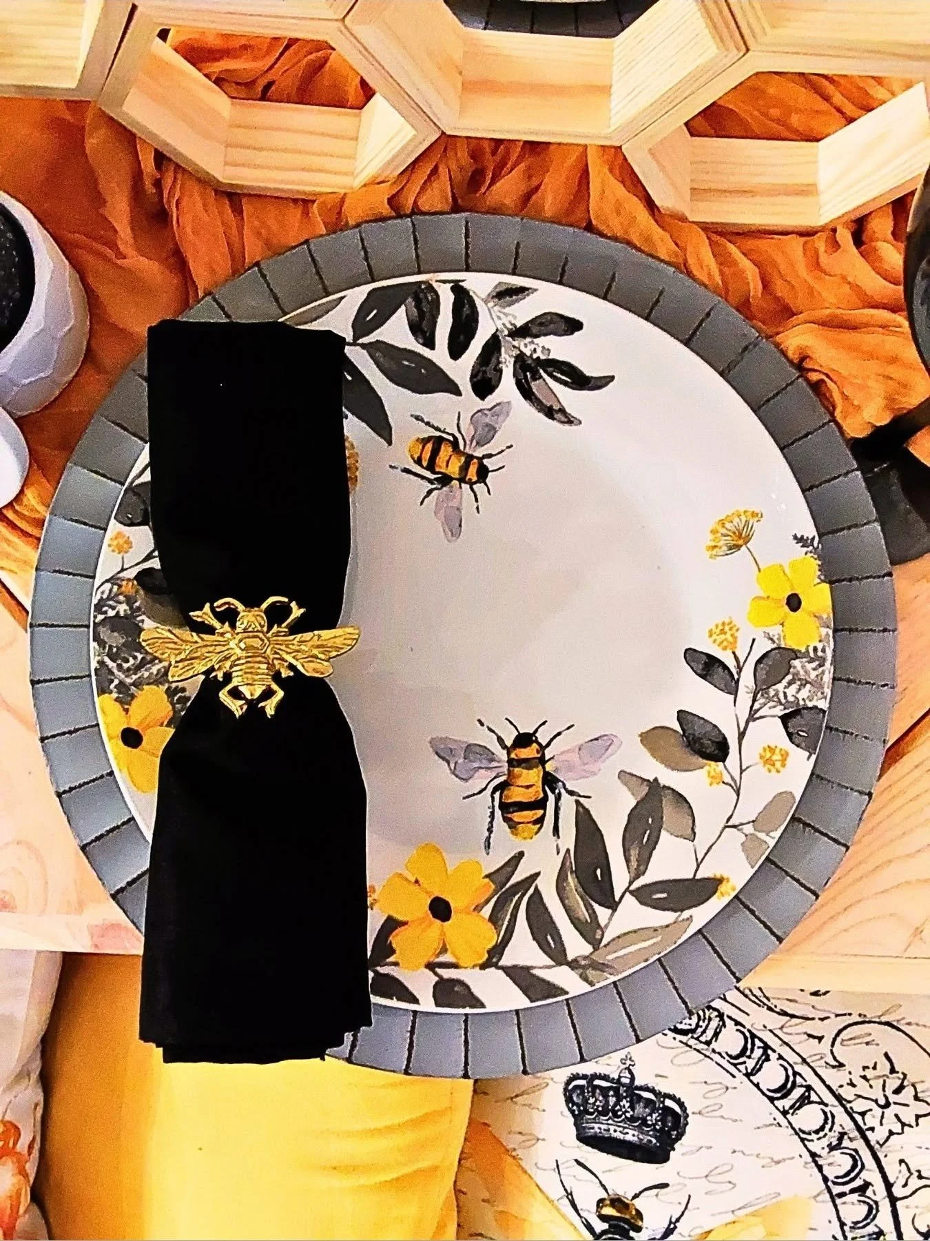 Decorative round tray with illustrations of bees, yellow flowers, and leaves, surrounded by a striped grey border.
