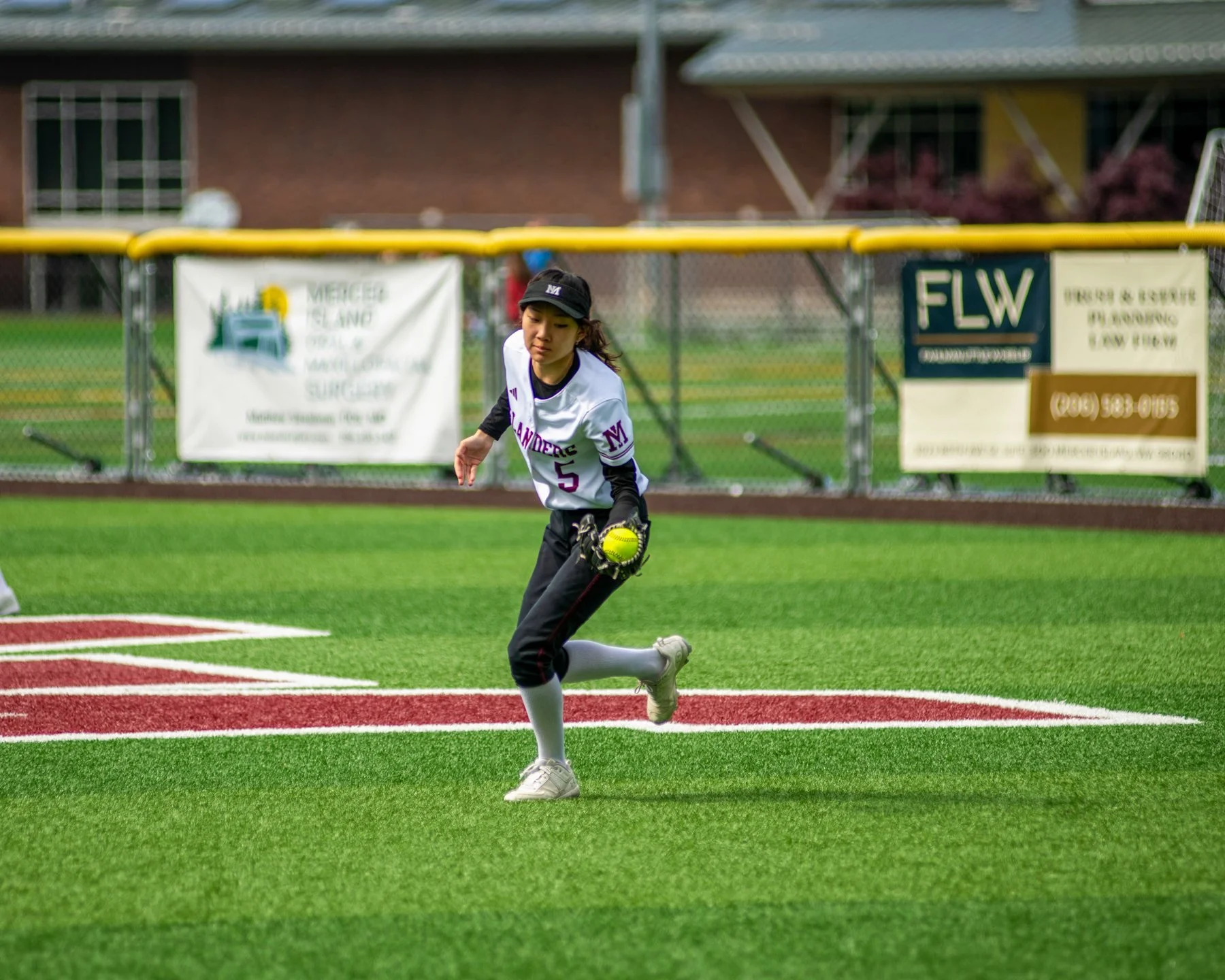 Islander softball player runs with the ball and glove.