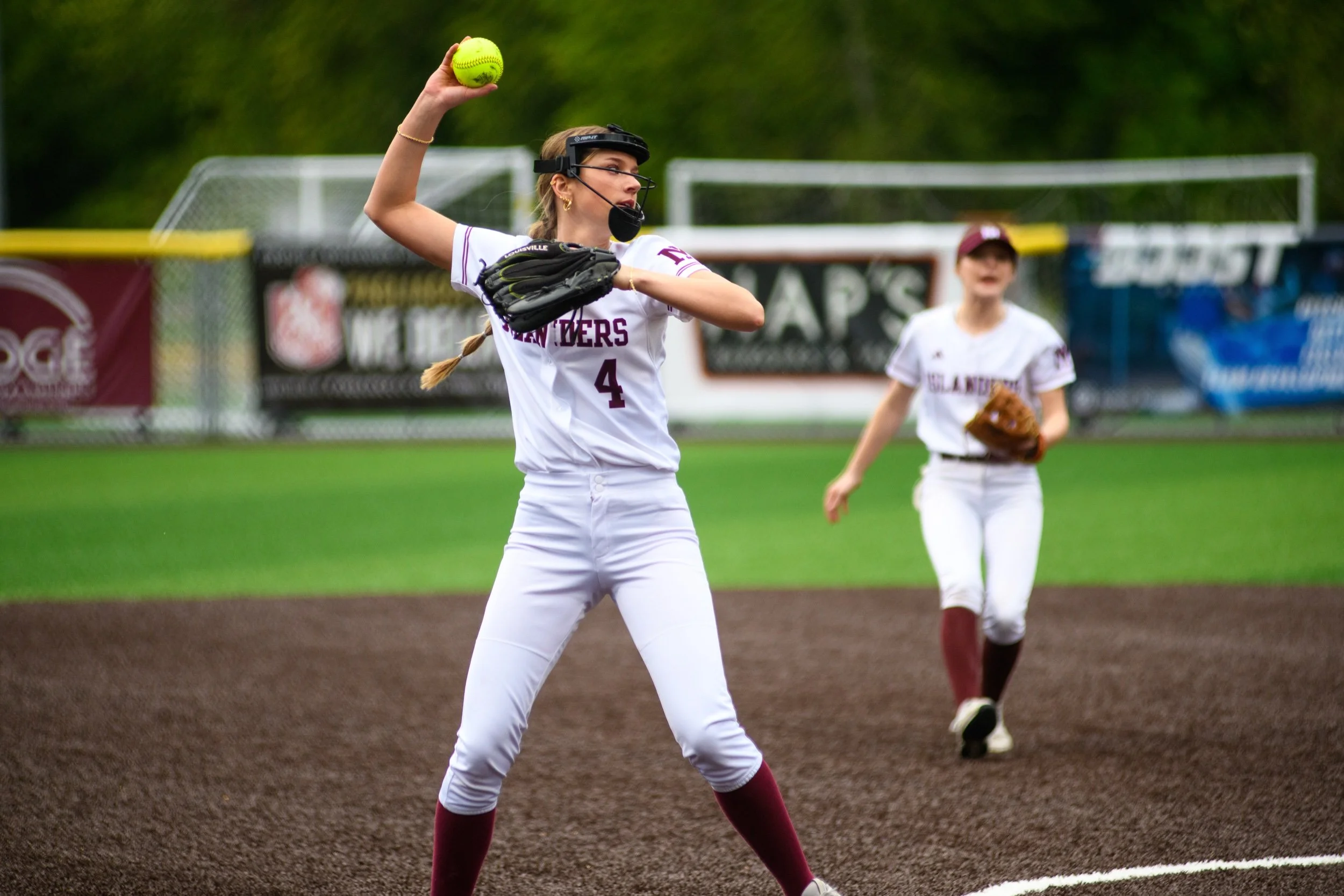 MIHS softball infielder throws the ball across the field.