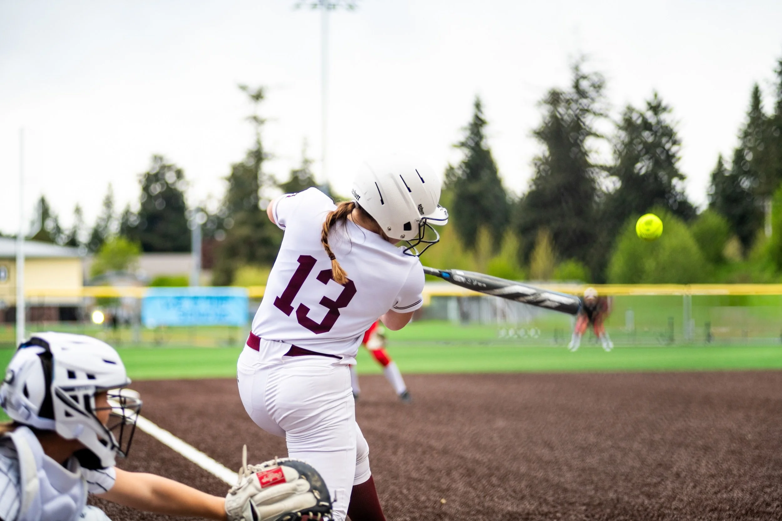 MIHS softball batter swings at an approaching pitch.