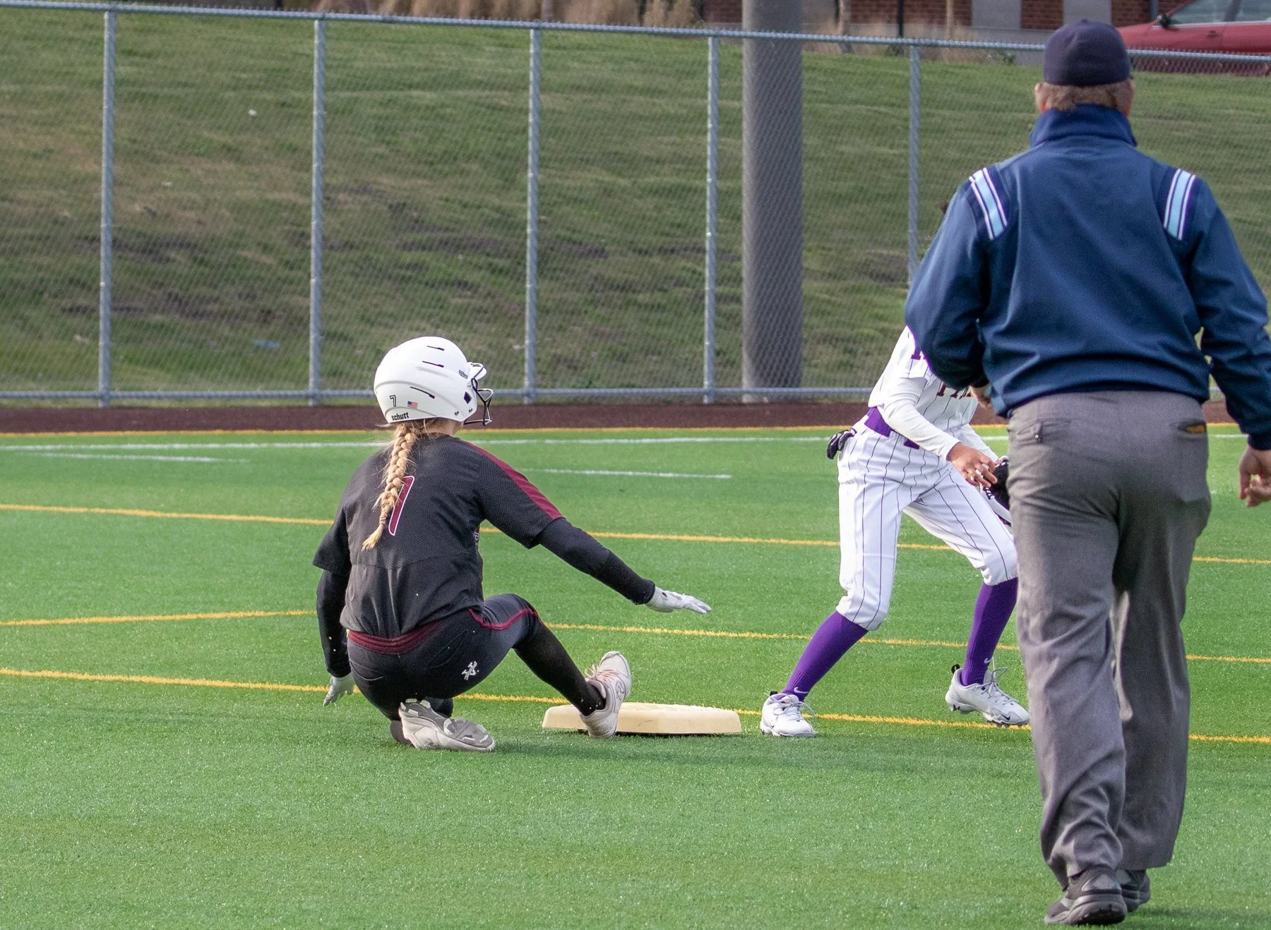 Islander softball fielder reaches toward a base as a runner approaches.