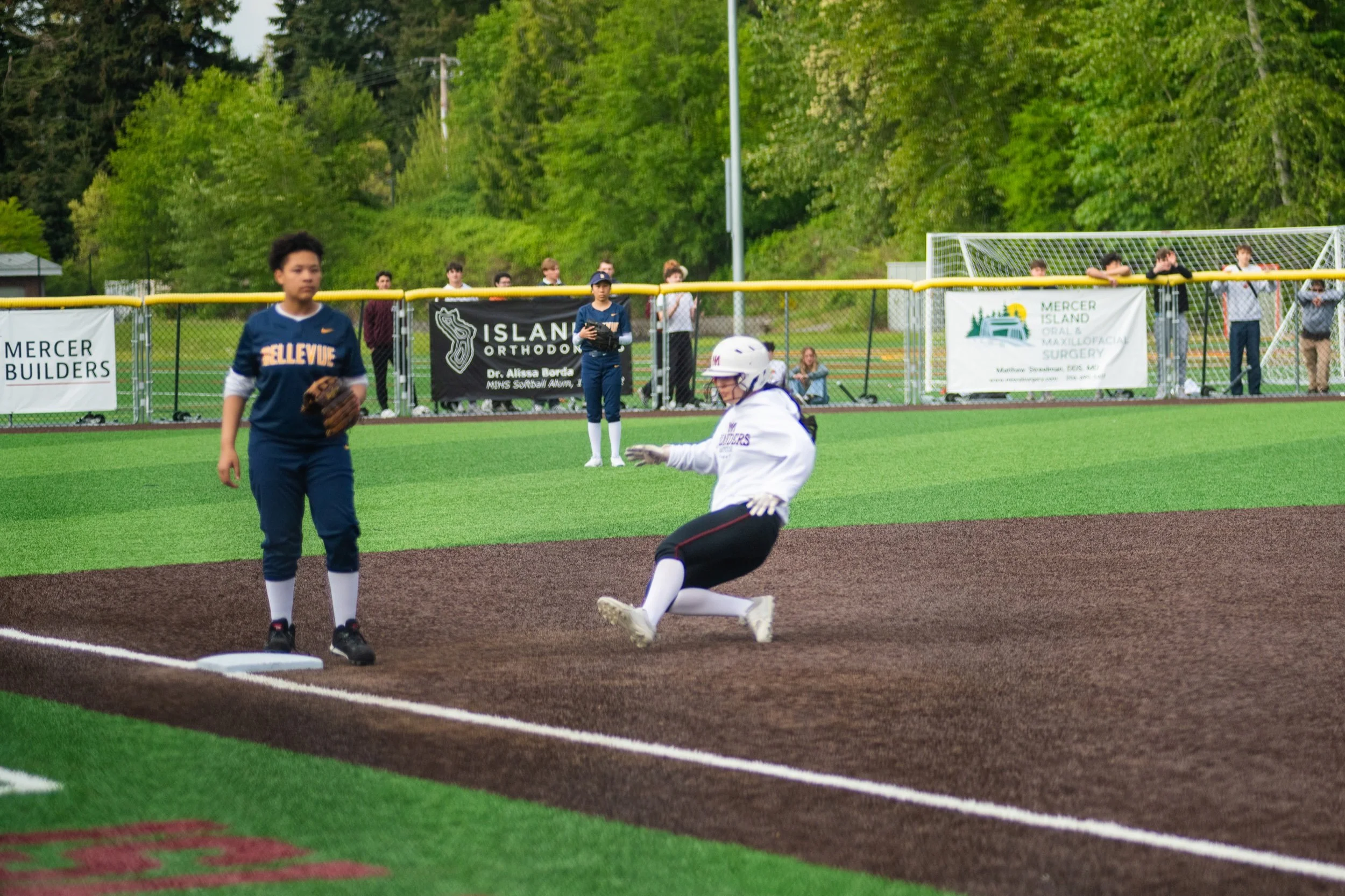 MIHS softball runner slides toward a base.