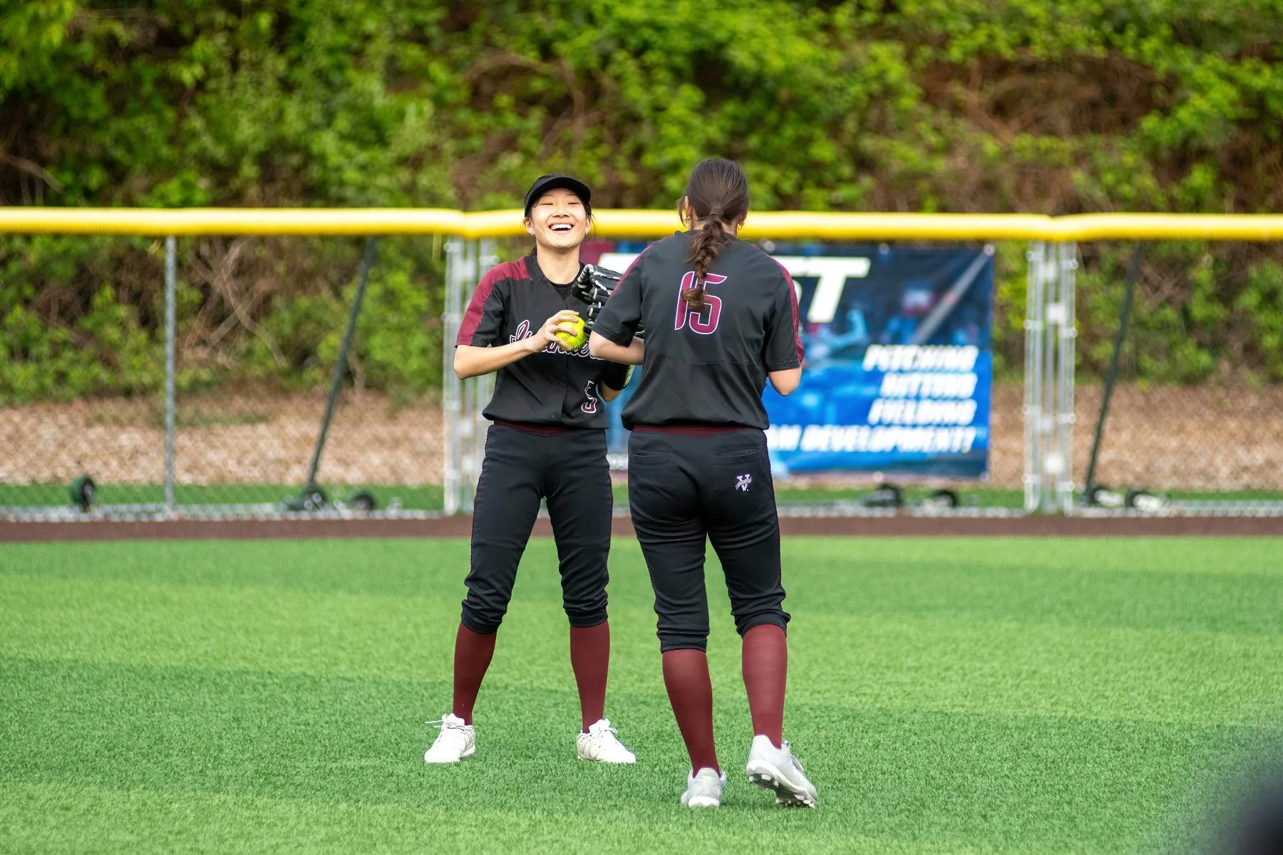 Islander softball teammates gather on the field.