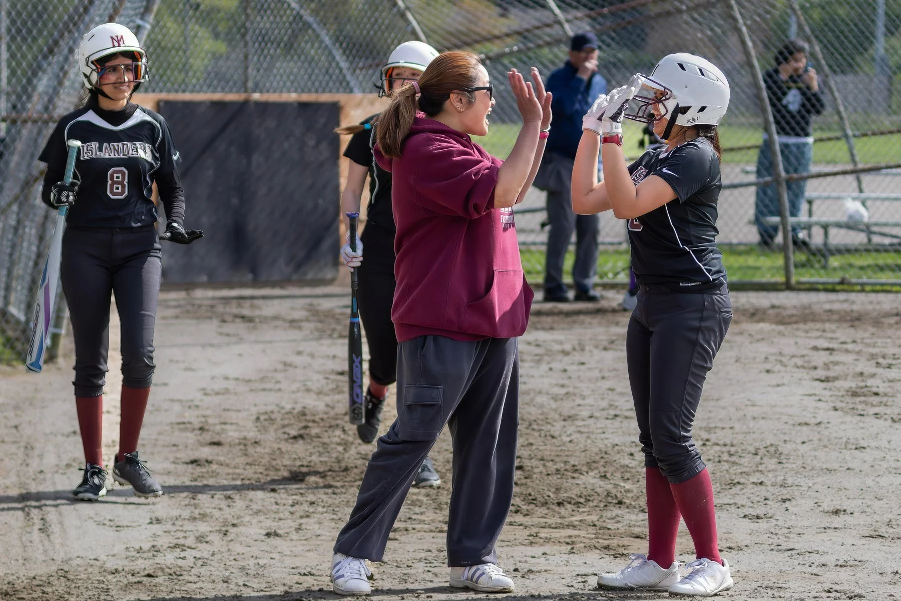 Coach and softball player exchange a high-five.