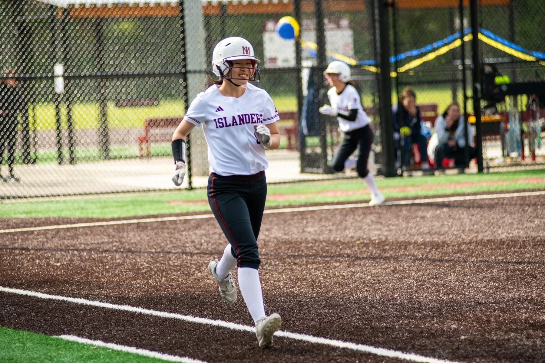 MIHS softball runner sprints along the baseline.