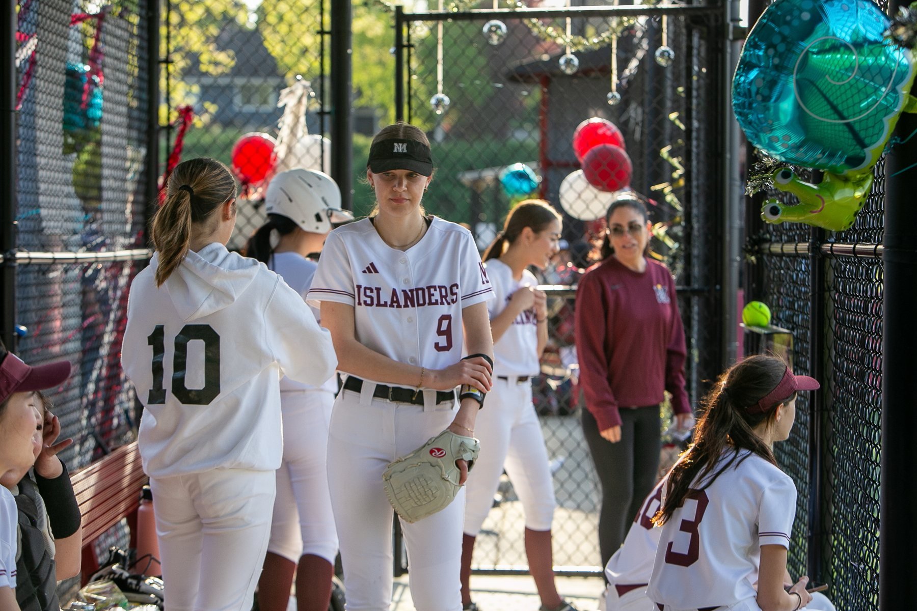 MIHS softball teammates gather in the decorated dugout.