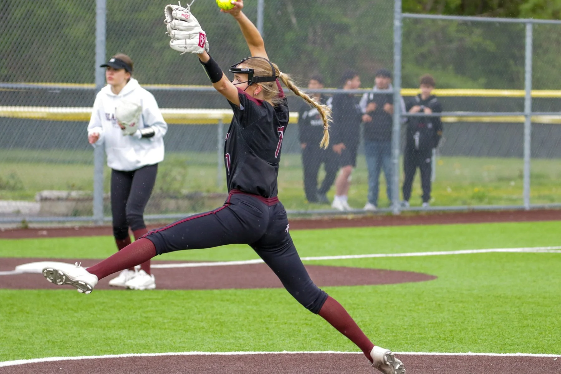 Islander softball pitcher strides forward to deliver a pitch.