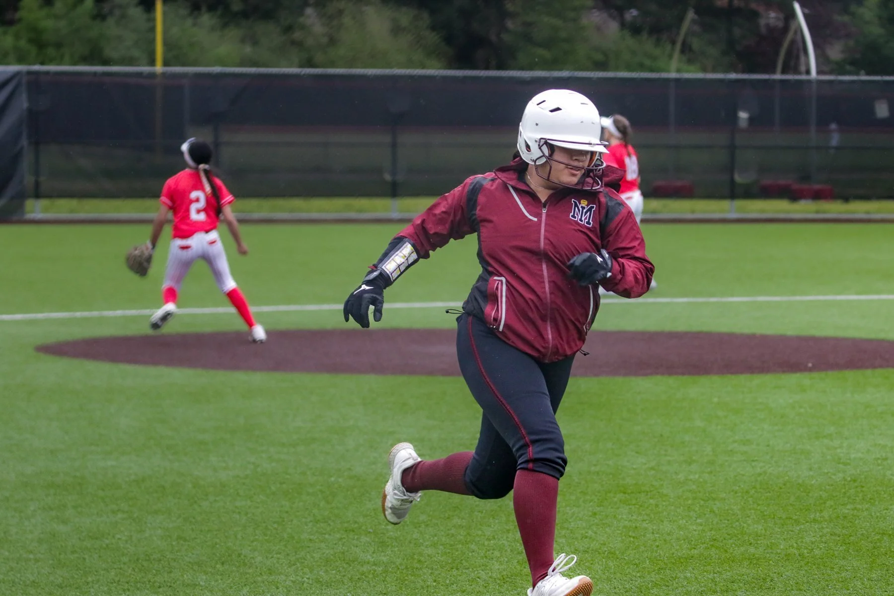 Helmeted Mercer Island softball runner sprints across the field.