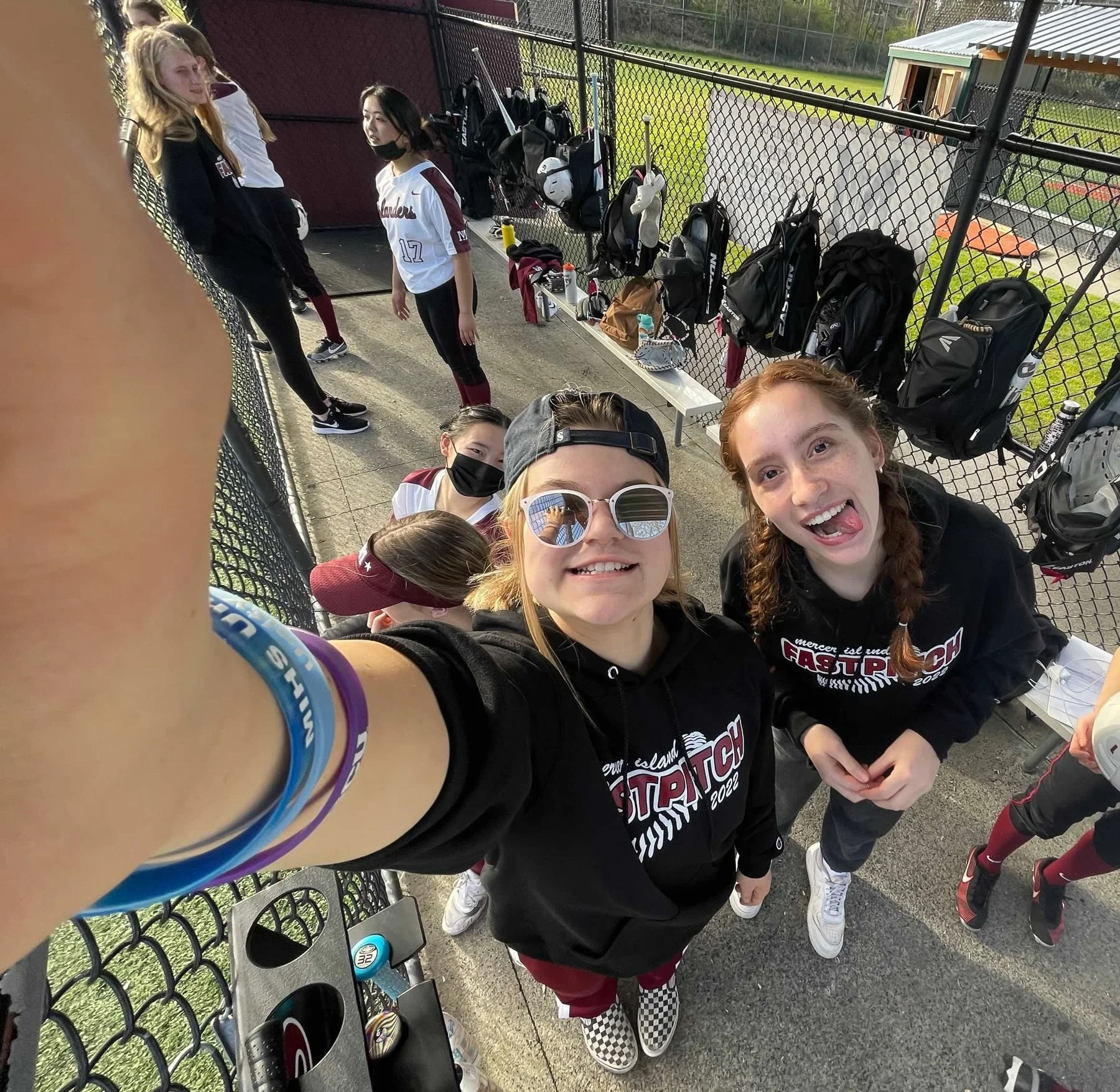 Two MIHS softball teammates take a selfie beside the dugout.