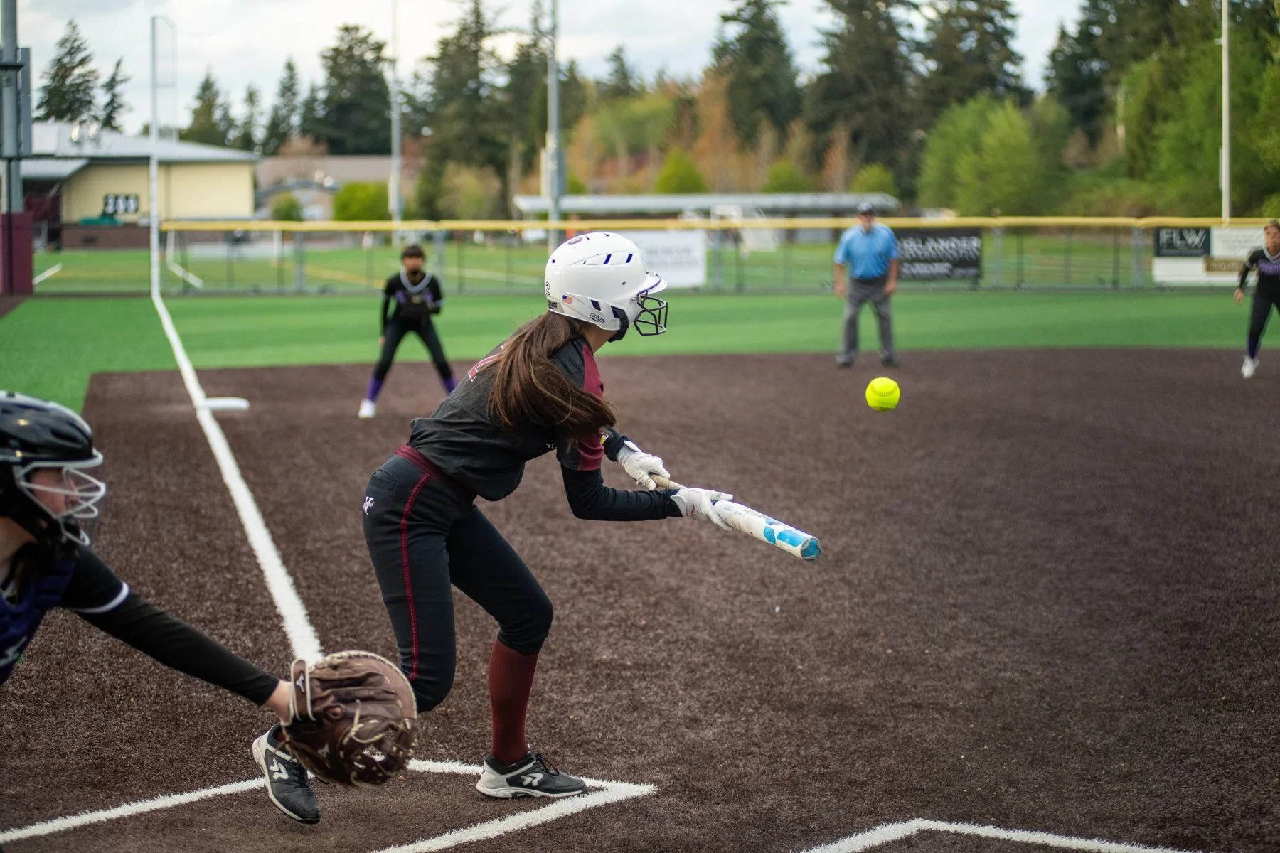 Islander softball batter meets a pitch with her bat.