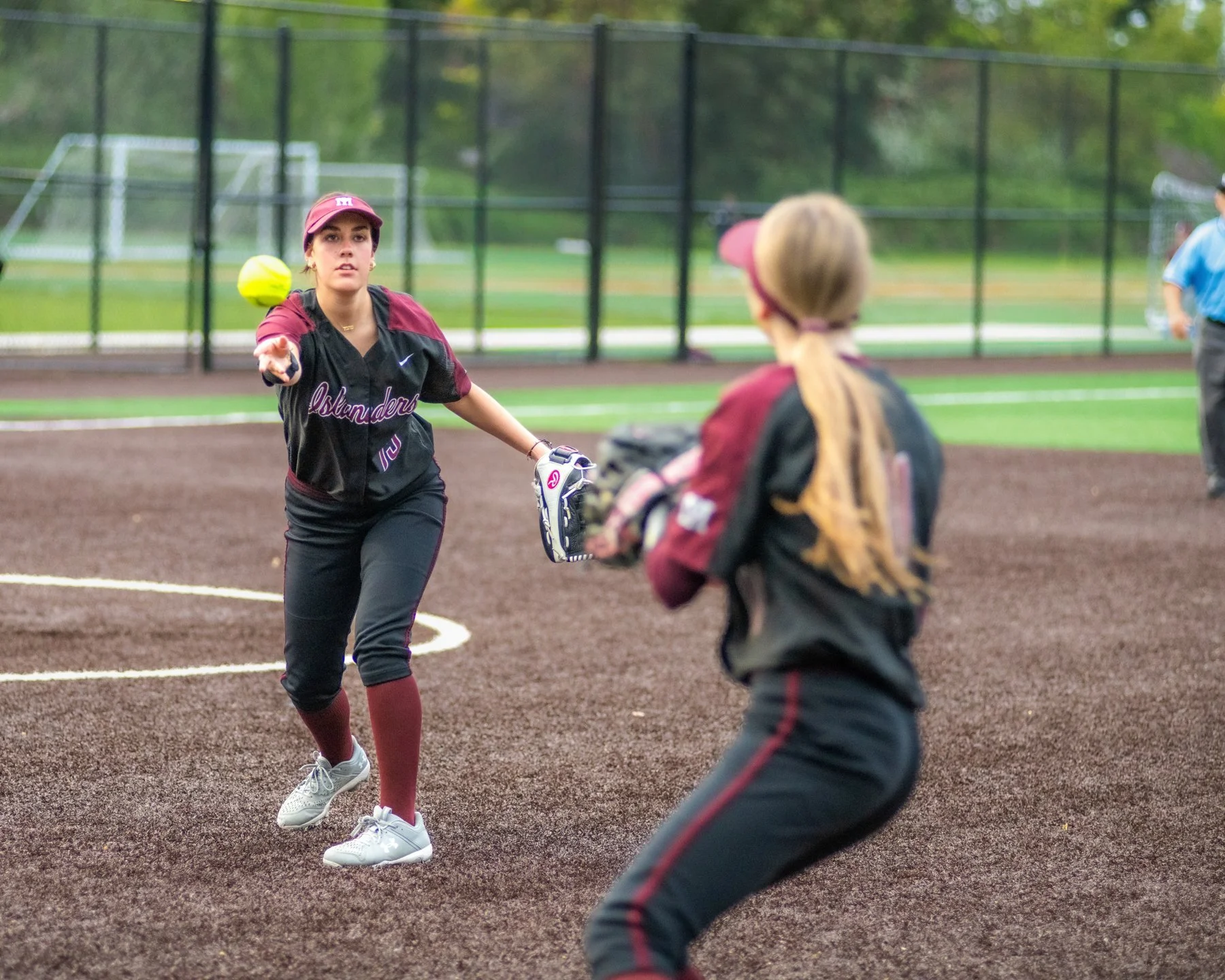 MIHS softball teammates practice a short toss on the infield.