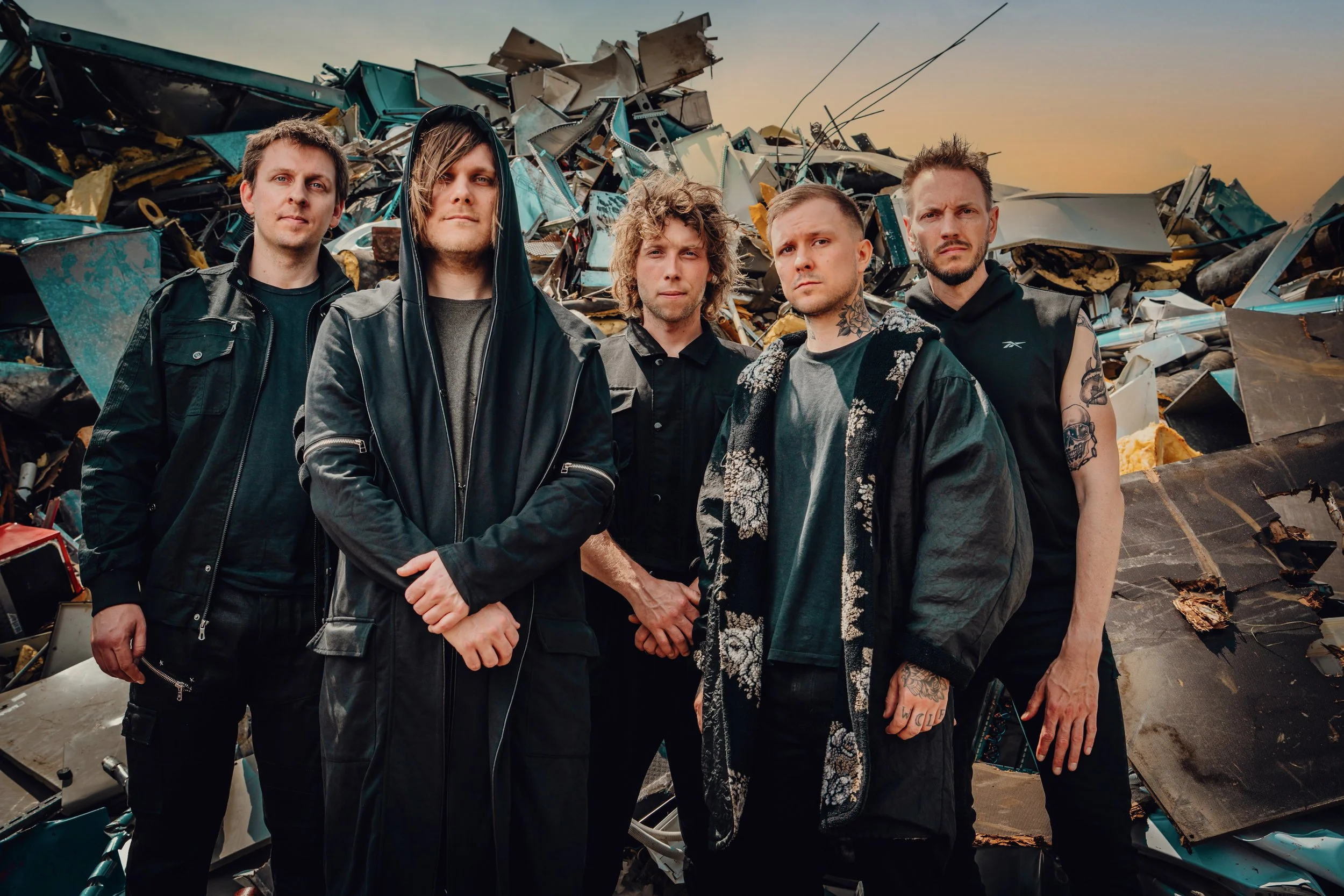 Press photo of the five members of ONLY HUMAN standing in front of a pile of trash and debris. Left-to-right: Martin, Patrick, Andreas, Guillaume, Jack.