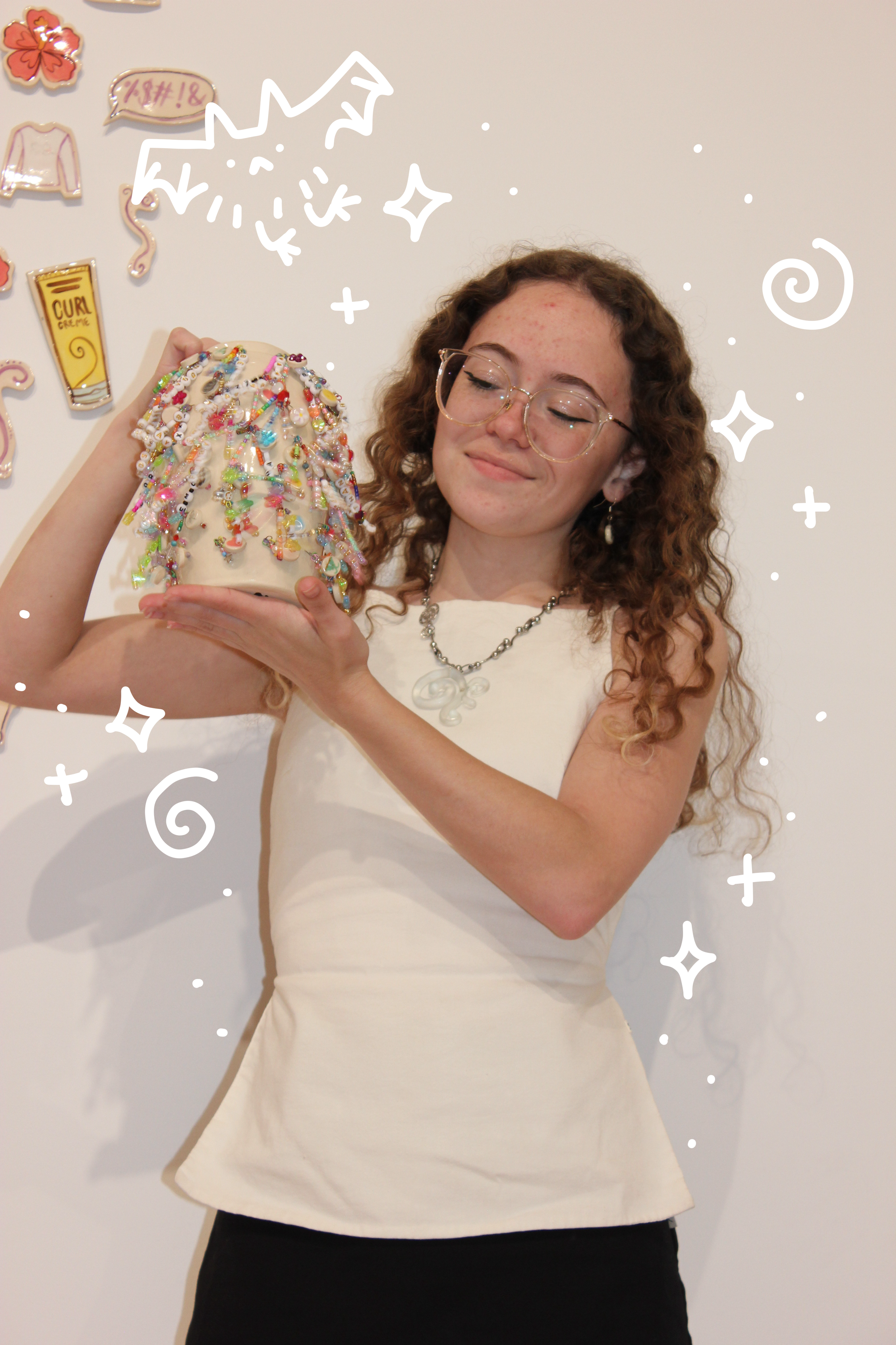 Haili holding a ceramic vase covering charms with doodles overlayed