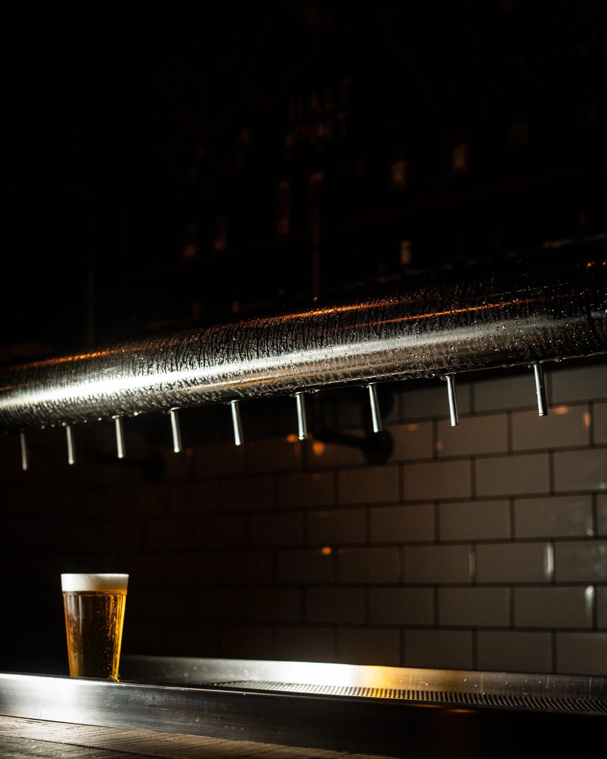 Torneiras de chopp e copo de cerveja no balcão do Osso Parrilla Bar na Cidade Baixa