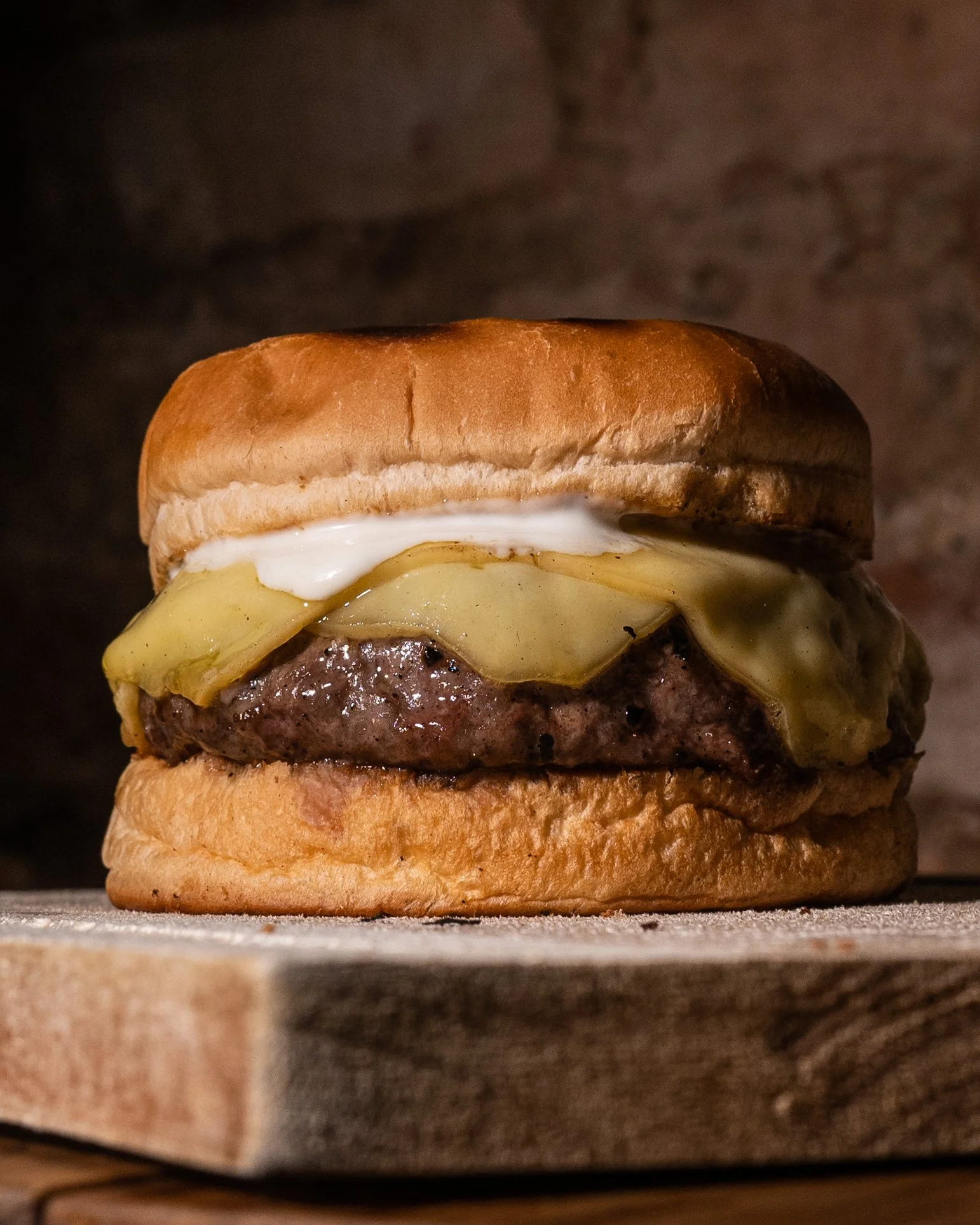 Hambúrguer Carne e Queijo: 200g de carne assada na brasa com queijo colonial derretido, sobre tábua de madeira